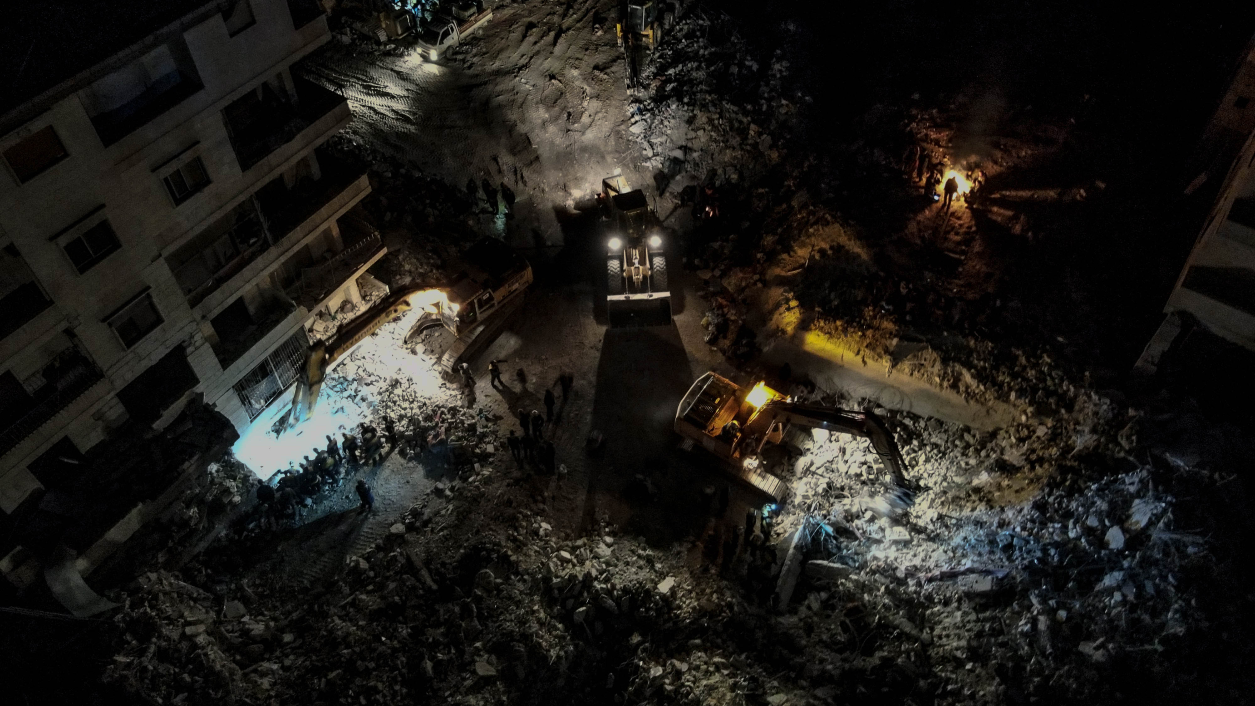 Volunteer rescue workers dig through rubble late into the night in northwest Syria looking for survivors (MEE/