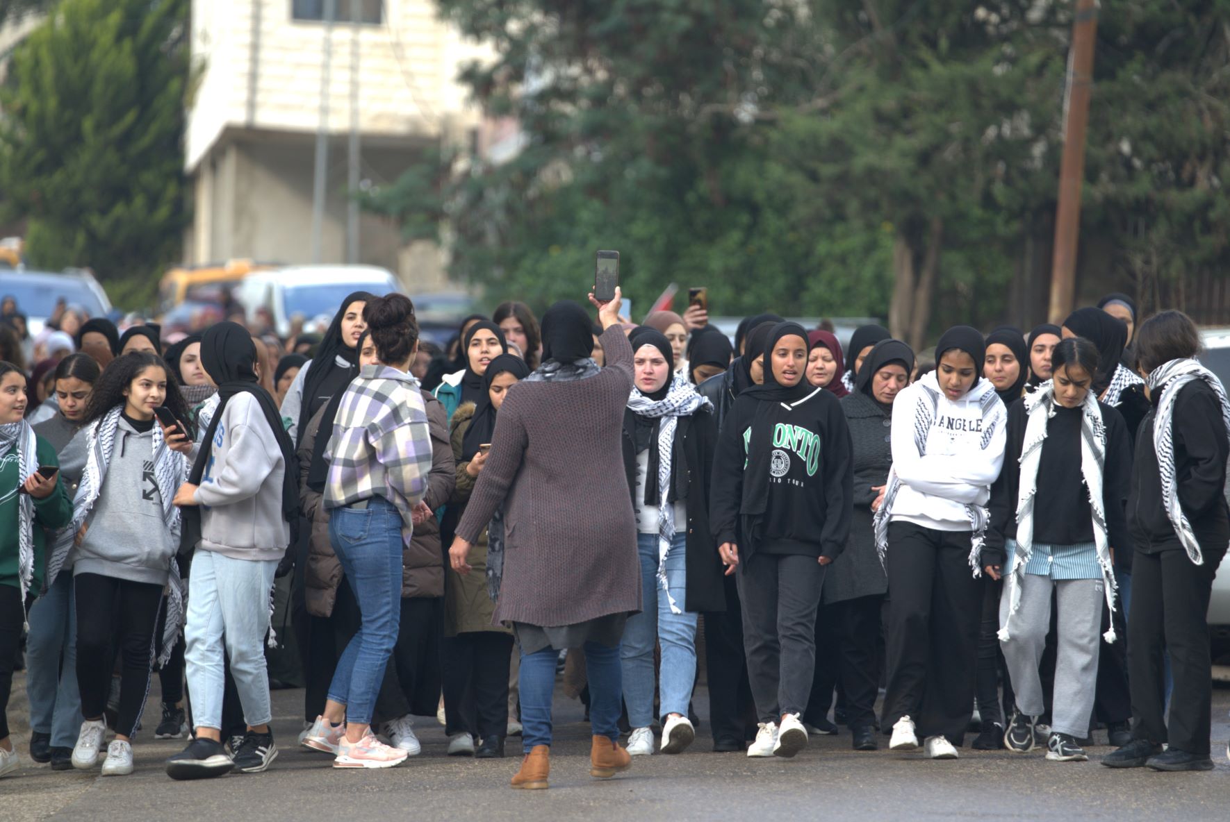 During the funeral processions for the martyred Rimawi brothers, Palestinian women march through the streets to honour them (MEE/Akram al-Waara)