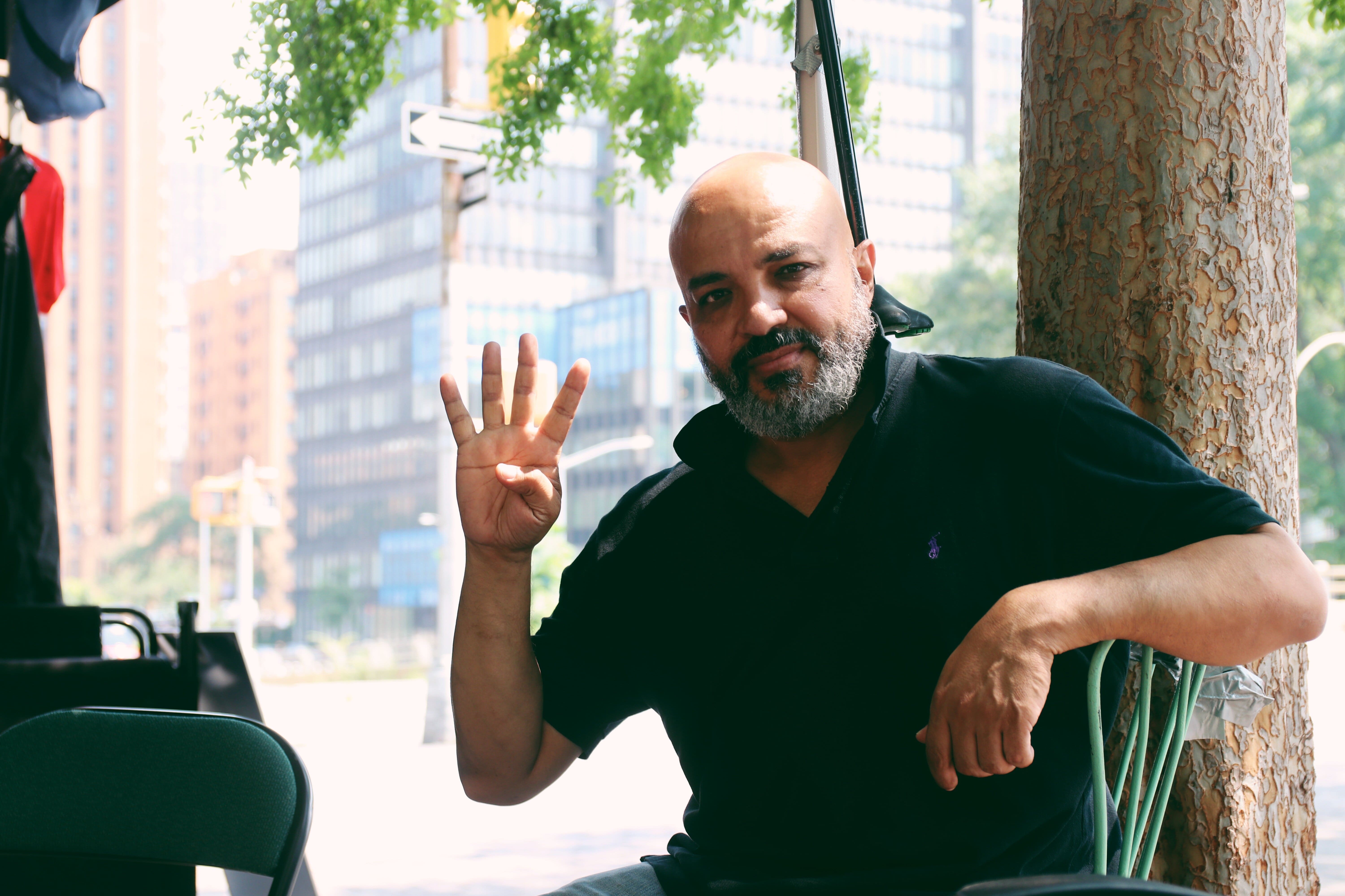 Bahgat Saber makes the Rabaa sign, a hand symbol that was created after the violent clearing of protest sit-ins at Cairo’s Rabaa al-Adawiya Square and al-Nahda Square (MEE/Zainab Iqbal)