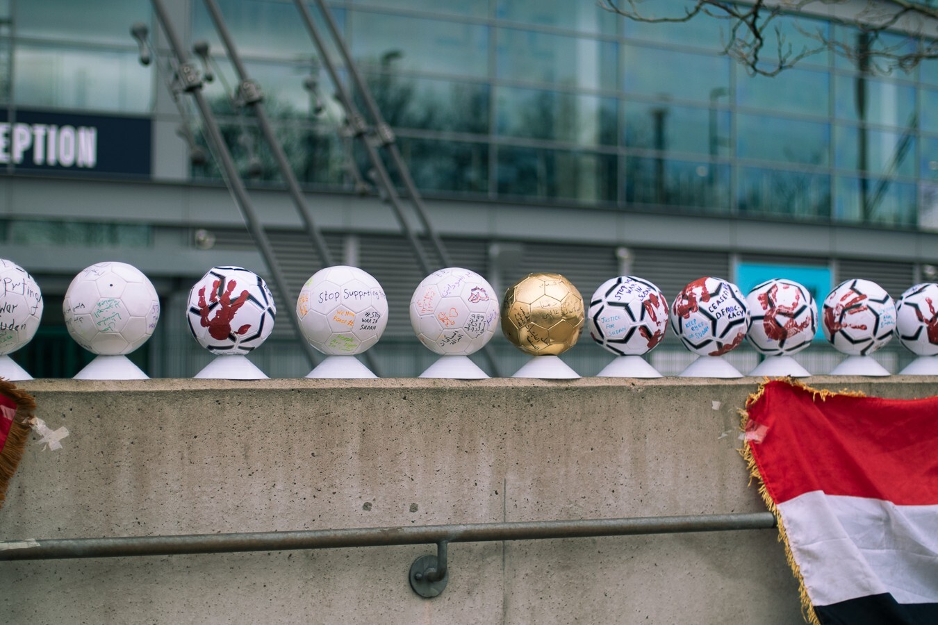 Footballs signed with anti-war messages by Sudanese refugees are displayed outside the Etihad Stadium in Manchester (Supplied)