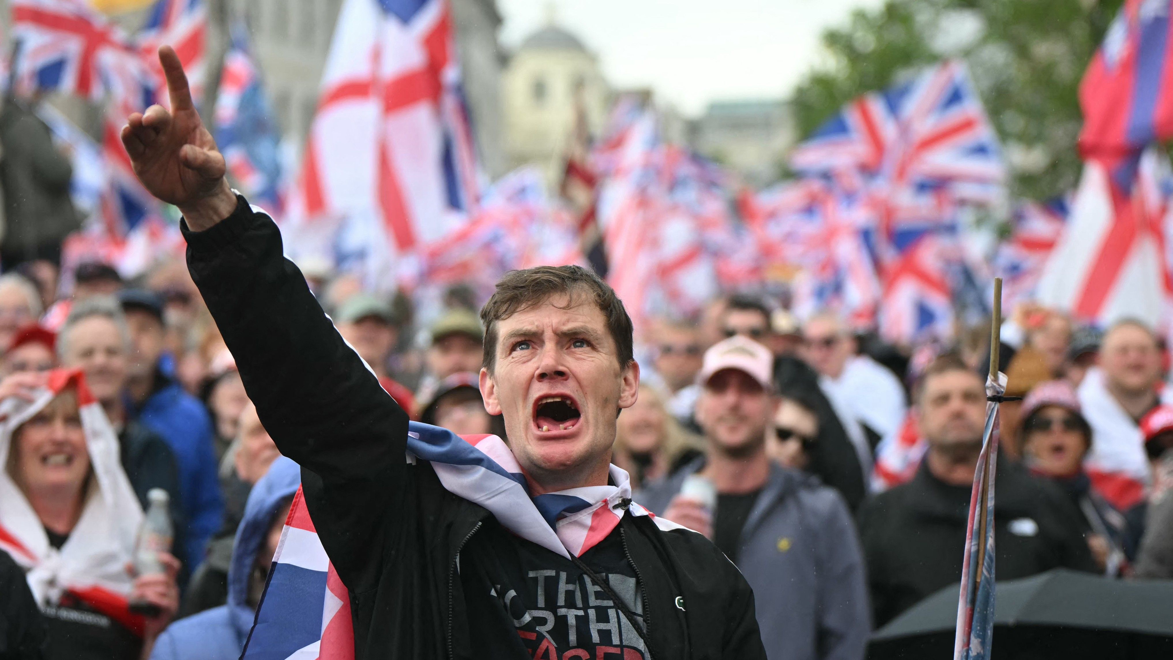 Supporters of British far-right activist Tommy Robinson, real name Stephen Yaxley-Lennon, watch the speeches on screens (AFP)