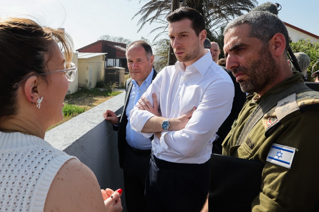 France's National Rally (RN) leader Jordan Bardella (C) speaks with residents of Netiv Haasara, a village targeted by the 7 October 2023 Hamas-led attack on southern Israel, on 26 March 2025 (Jack Guez/AFP)
