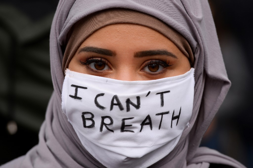 Une femme, portant un masque où est écrit en anglais « Je ne peux pas respirer », manifeste contre le racisme et les violences policières à la suite de la mort de l’Afro-Américain George Floyd, à Bordeaux, le 9 juin 2020 (AFP)