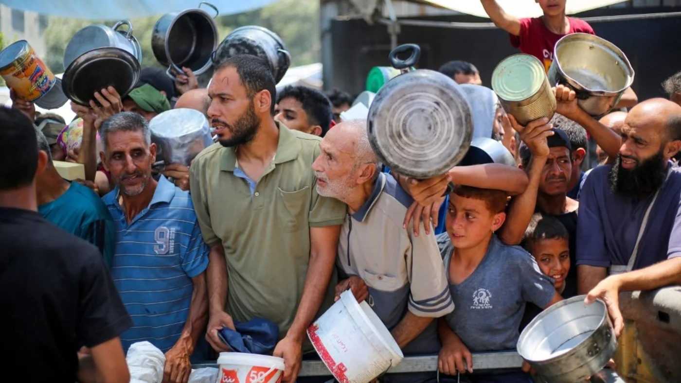 Palestinians wait for food at a distribution point in Nuseirat, in the central Gaza Strip, on 11 June 2025 (Eyad Baba/AFP)