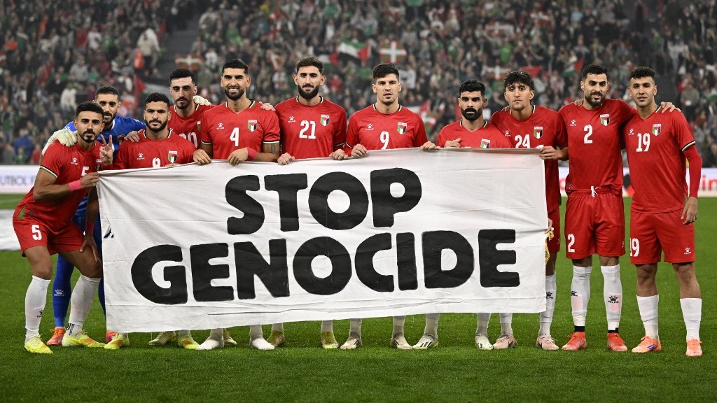 Palestin's players hold a banner reading 