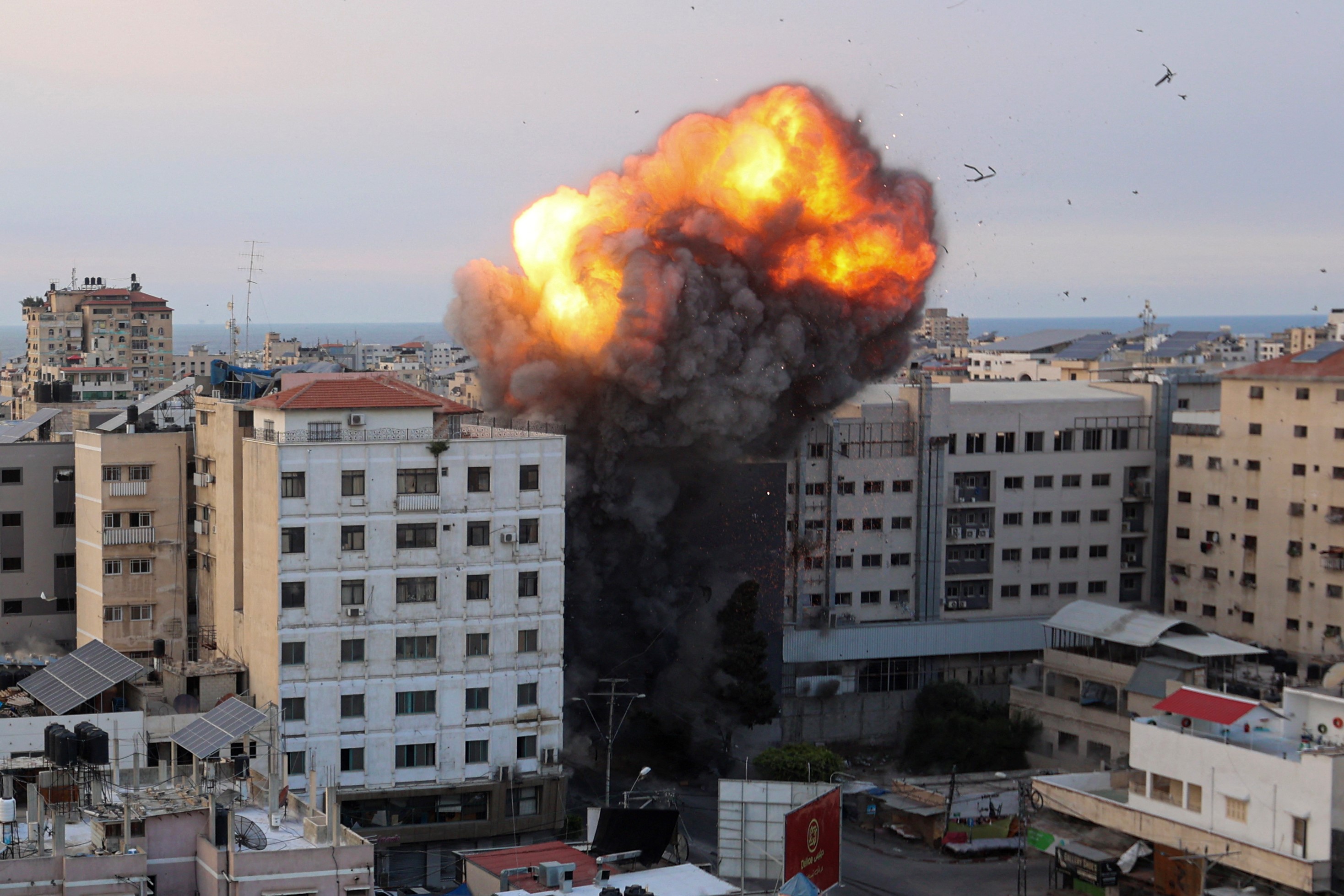 Fire and smoke rise after an Israeli air strike targeted the National Bank on Gaza City, on 8 October 