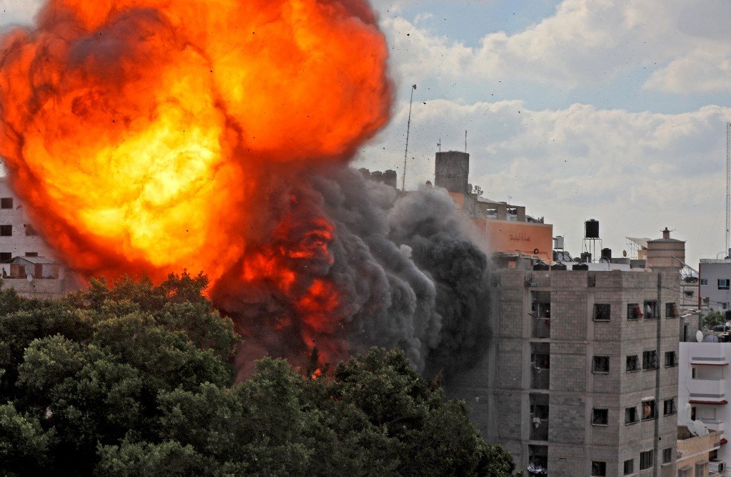 A ball of fire engulfing the Al-Walid building which was destroyed in an Israeli air strike on Gaza city early in the morning of 13 May (AFP)