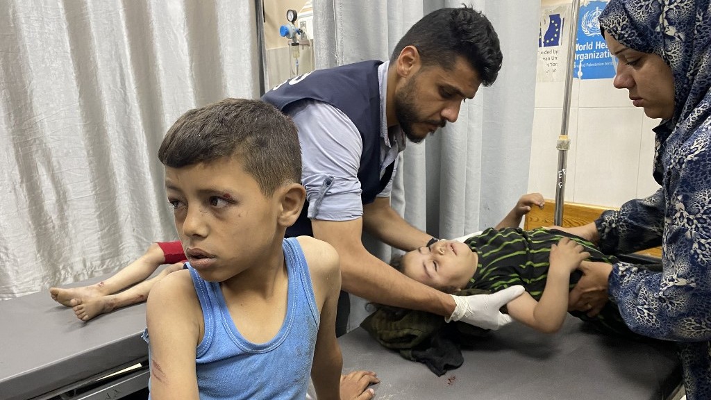 A Palestinian medic cares for children who were injured in Israeli strikes, at the Nasser hospital in Khan Yunis in the southern Gaza Strip on May 15, 2025.