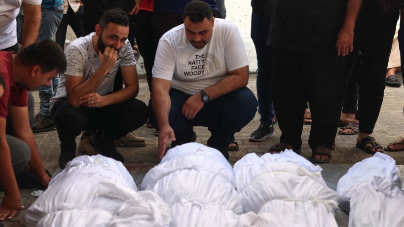Palestinians mourn over the bodies of relatives after overnight Israeli strikes on Rafah in the southern Gaza Strip on October 22, 2023 (AFP)