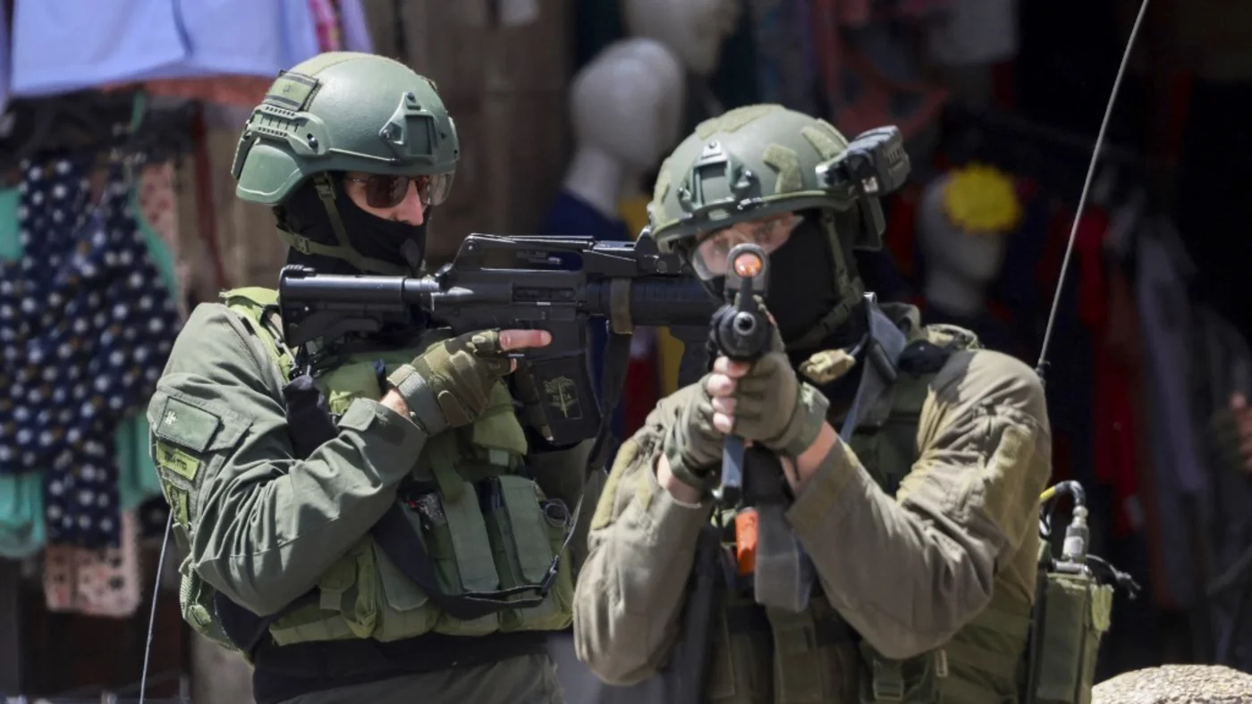 Israeli soldiers aim their rifles during a raid in the Palestinian city of Nablus, in the occupied West Bank, on 27 May 2025 (AFP/Jaafar Ashtiyeh)