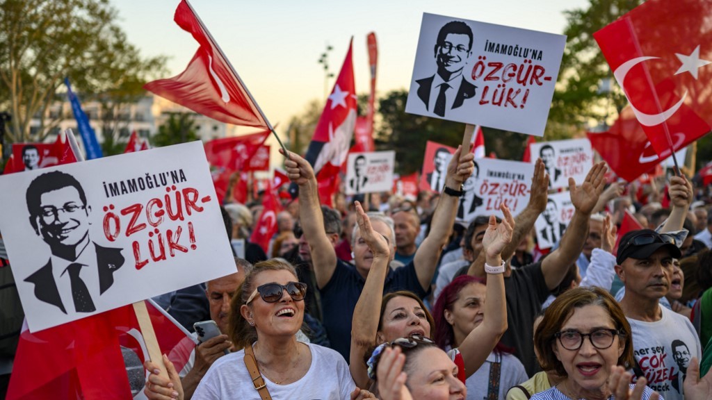 Protesters hold Turkish flags and placards reading 'Freedom for Imamoglu' as they take part in a demonstration against the detention of the Mayor of Istanbul in May 2025 (Yasin Akgul/AFP)