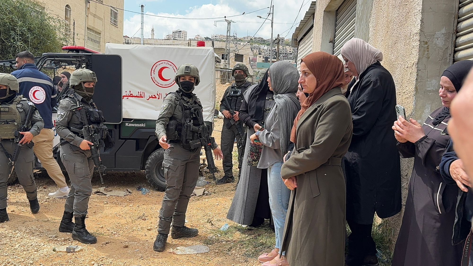 Israeli soldiers man the entrance to Jenin refugee camp as Palestinian women queue to enter and check their homes on 13 April 2026 (MEE/Mohammed Atiq)