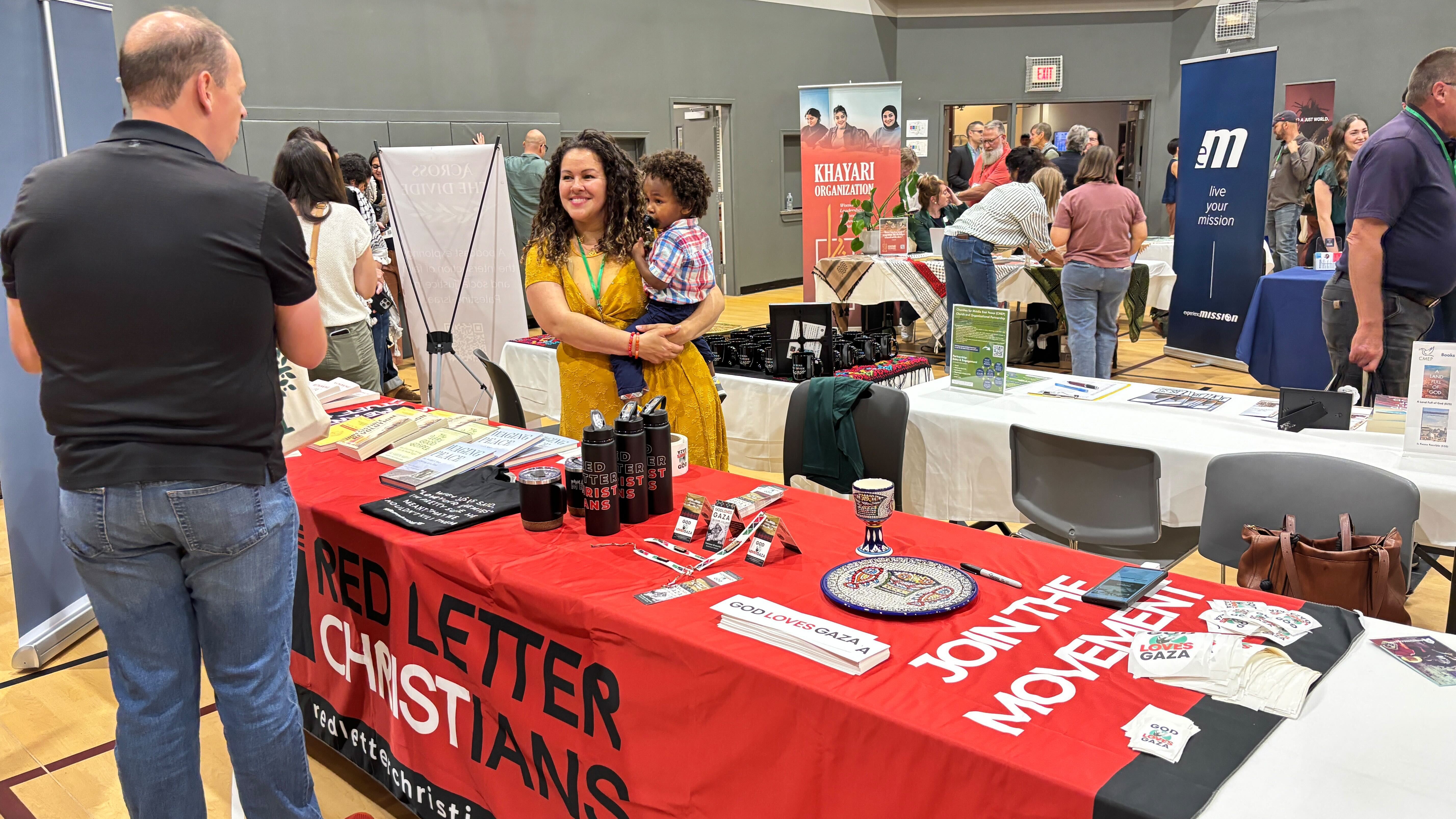 Red Letter Christians, which says its mission is to combine “Jesus and justice,” hands out “God loves Gaza” stickers at its booth at the Church at the Crossroads conference in Glen Ellyn, Illinois on 11 September 2025 (Yasmine El-Sabawi/MEE)