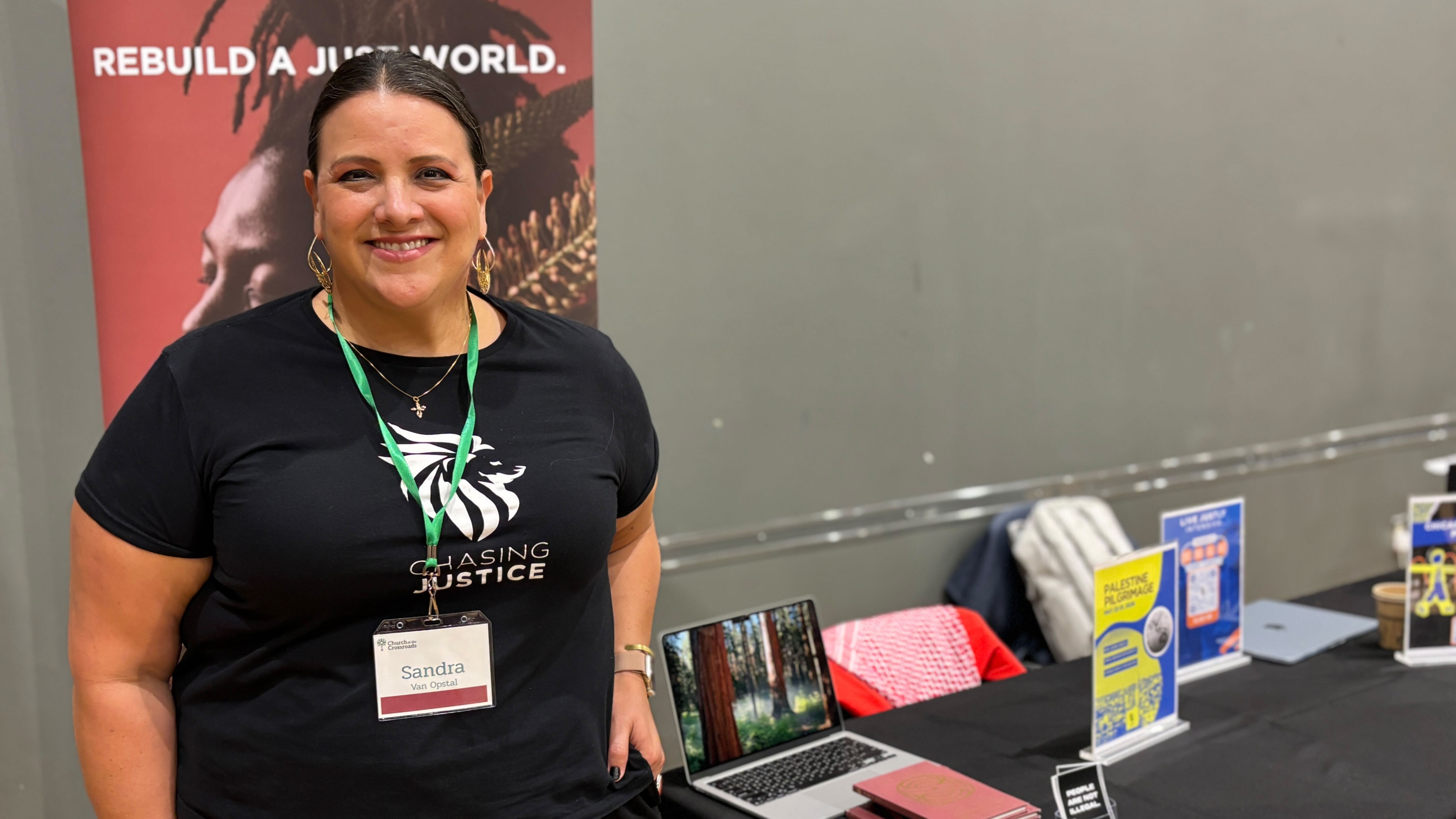 Sandra Maria Van Opstal, executive director of faith-based activism group Chasing Justice, poses for a photograph at her booth at the Church at the Crossroads conference in Glen Ellyn, Illinois on 11 September 2025 (Yasmine El-Sabawi/MEE)