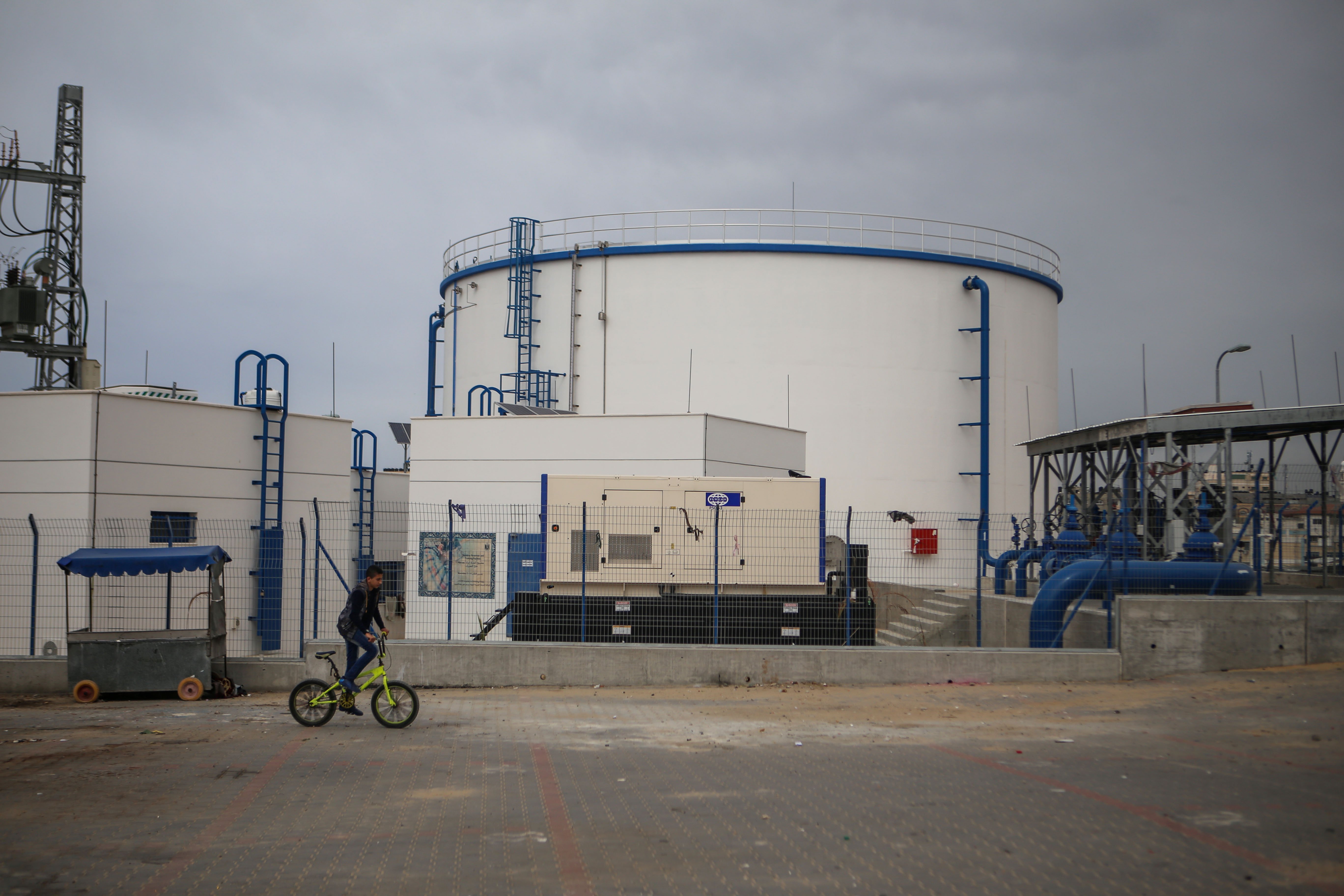 Un enfant passe à vélo devant une usine de dessalement gérée par l’autorité locale des eaux, dans le camp de réfugiés d’al-Nuseirat, le 15 mars 2019 (MEE/Mohammed al-Hajjar).