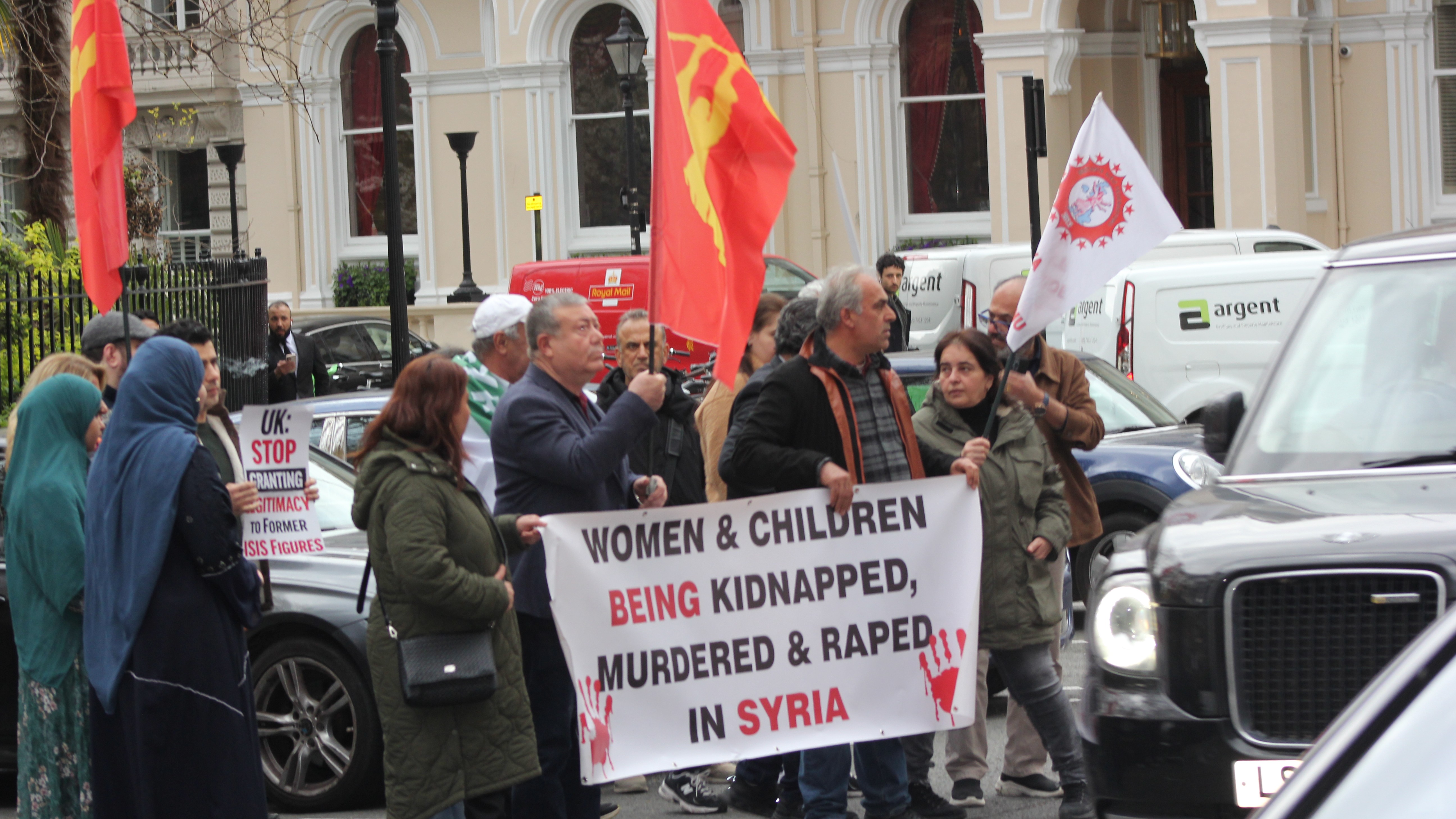 Alevi and Alawite protesters hold placards accusing Syrian President Ahmed al-Sharaa of overseeing the massacre of Alawites in Syria (MEE/Alex MacDonald)