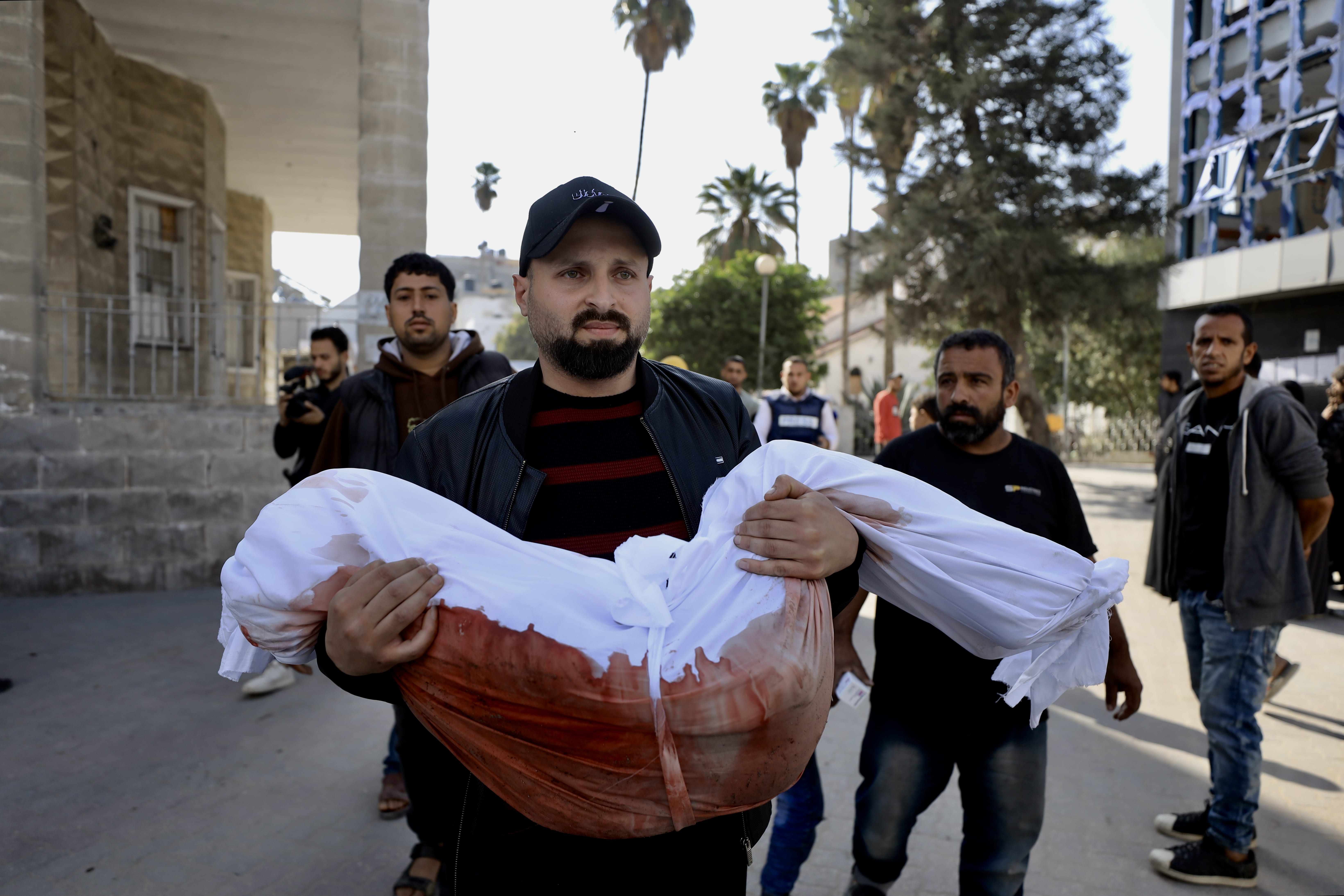 A mourner carries the body of a Palestinian child killed in an Israeli strike, in Gaza on March 18, 2025. (Mohammed al-Hajjar/MEE)