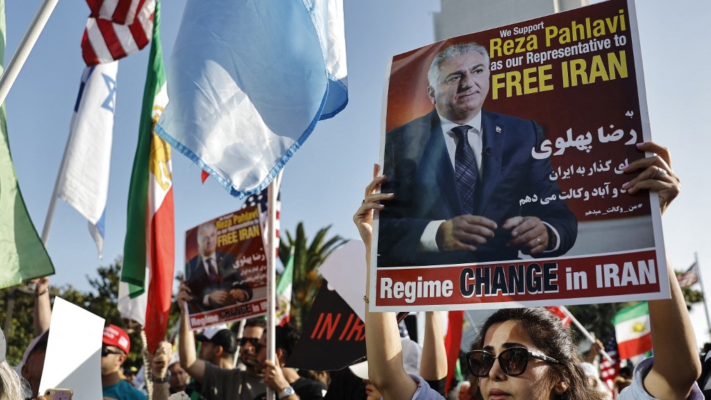 Supporters of regime change in Iran rally as a person holds a poster of exiled opposition leader Reza Pahlavi, outside the Wilshire Federal Building, on June 23, 2025 in Los Angeles, California (AFP)