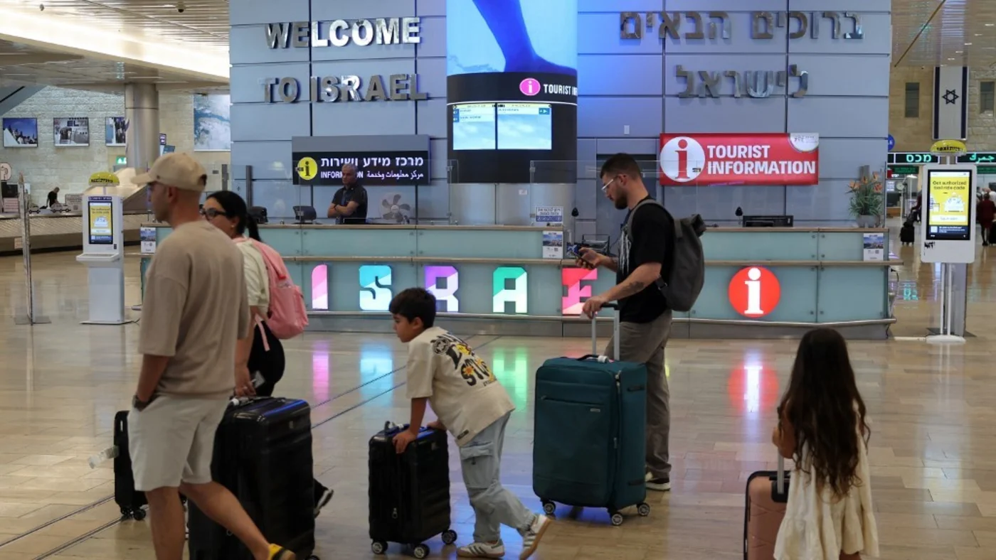 Incoming travellers walk with their luggage upon arrival at Israel's Ben Gurion Airport on 25 June 2025 (AFP/Jack Guez)
