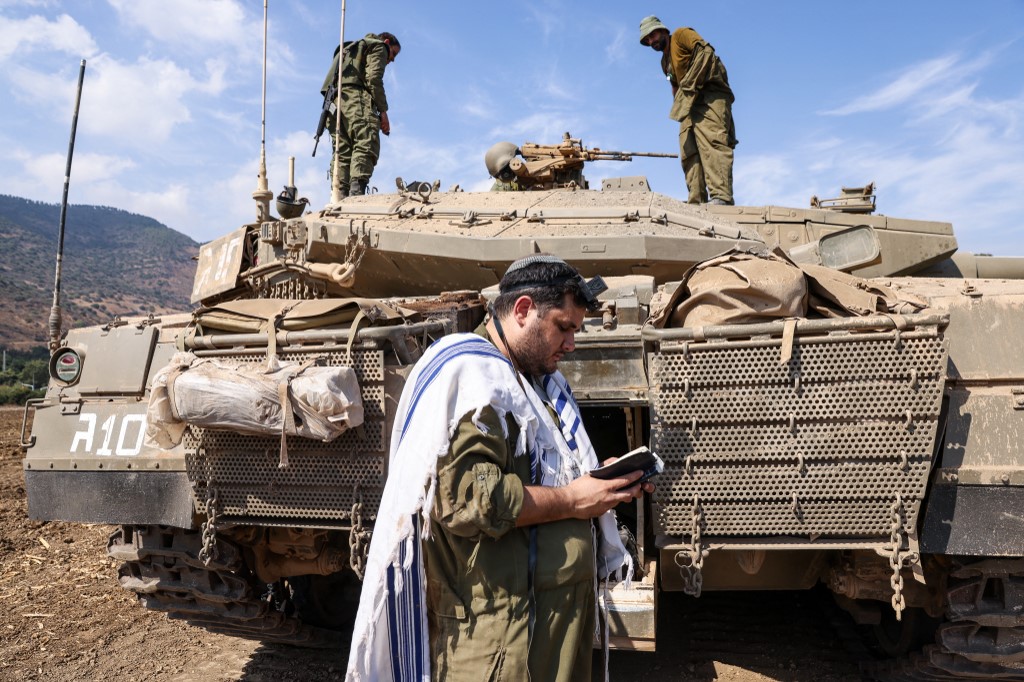 An Israeli soldier walks past a tank near Sderot on October 8, 2023. 
