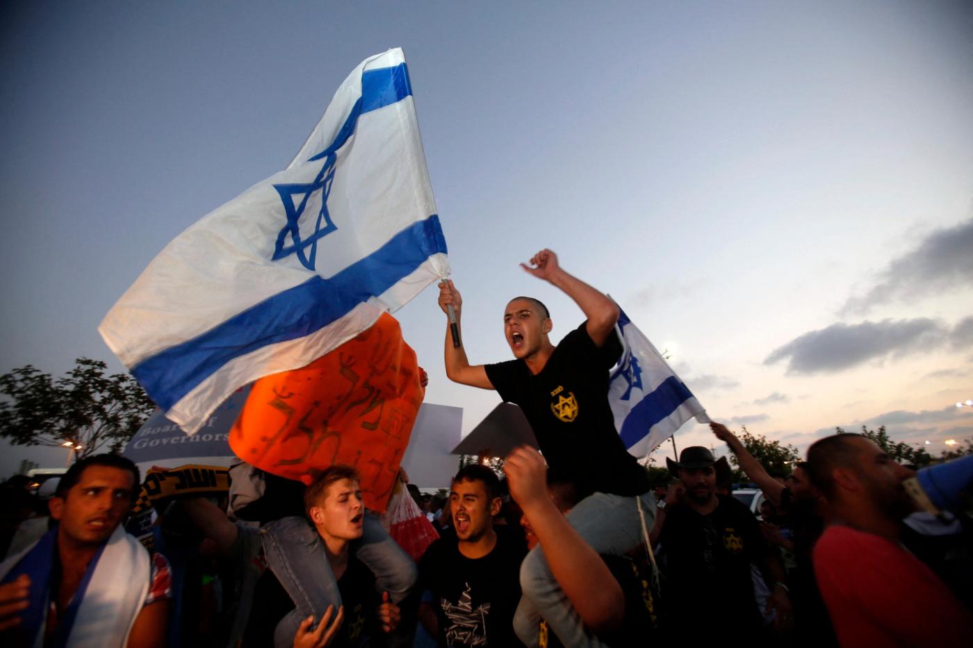 Lehava supporters chant slogans against the wedding of a Palestinian citizen of Israel and a Jewish-Israeli on 17 August 2014 (AFP)