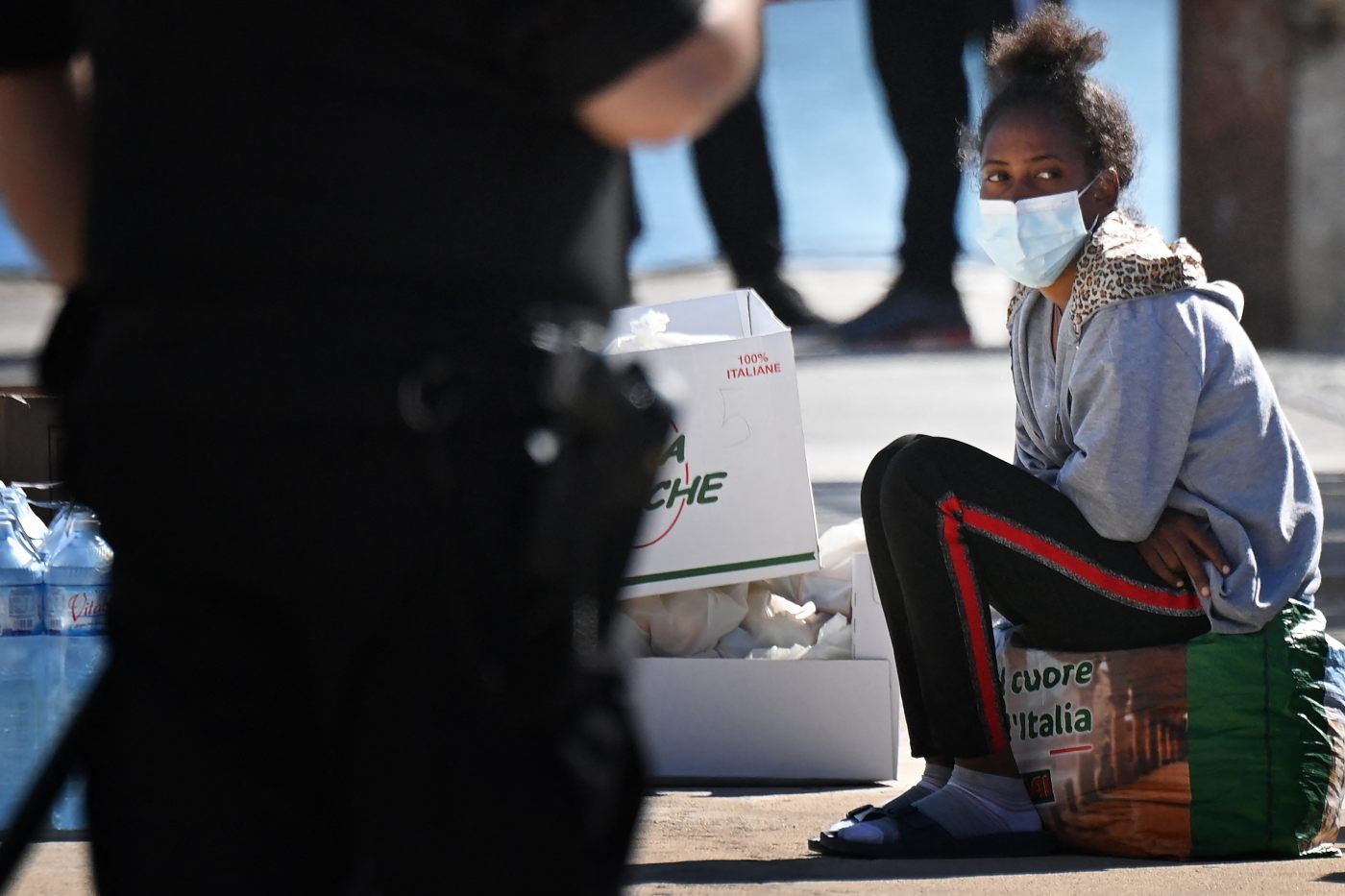 A young migrant waits to board a ferry to be transferred to Sicily and then to Apuglia, on 16 May 2021 on the southern Italian Pelagie Island of Lampedusa (AFP)