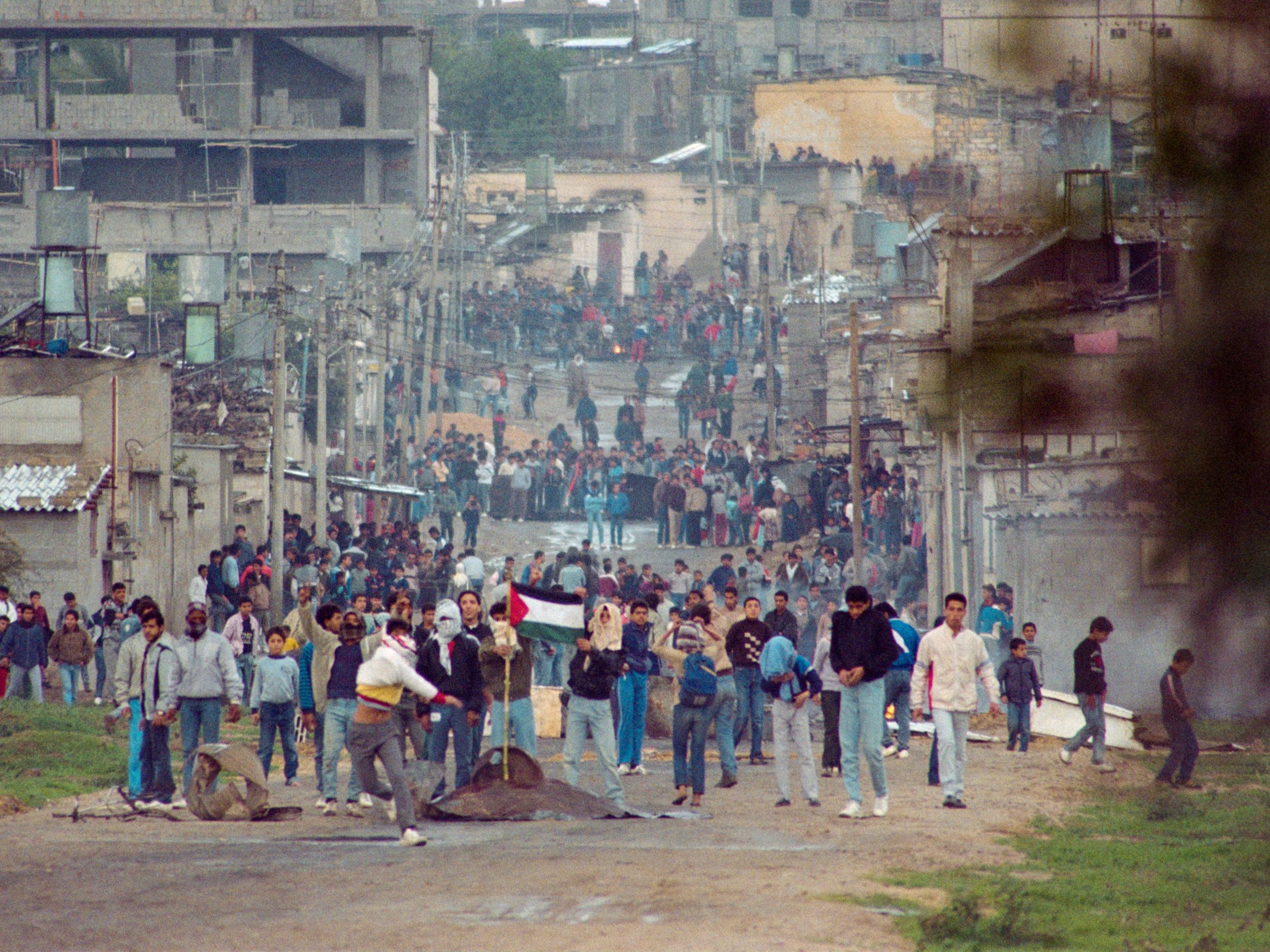 Palestinian youths, holding a Palestinian flag, throw rocks in Gaza during violent demonstrations on December 14, 1987 on the seventh day of the First Intifada (SVEN NACKSTRAND/AFP)