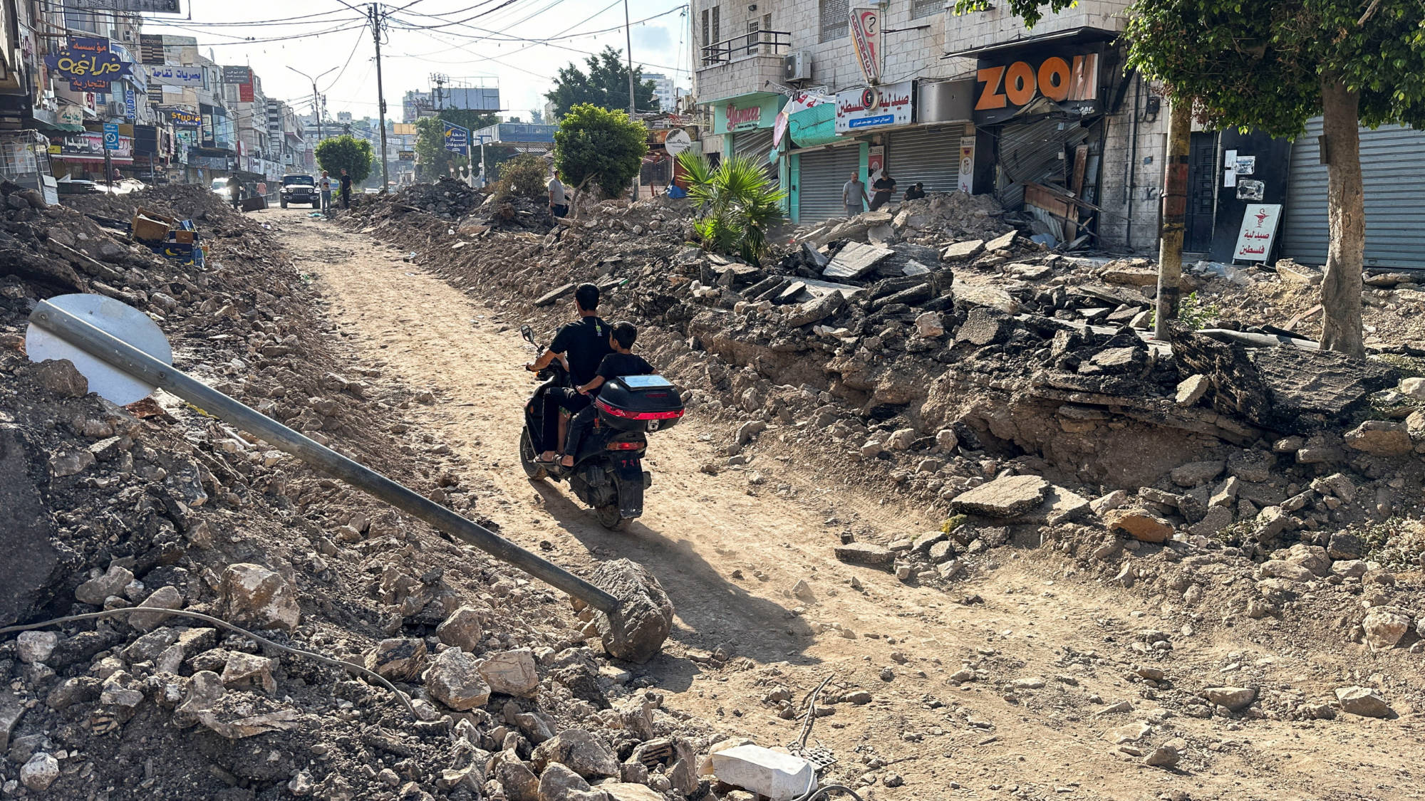 Palestinians ride a motorcycle on a damaged street following an Israeli military operation in Jenin in the Israeli-occupied West Bank September 6, 2024. 