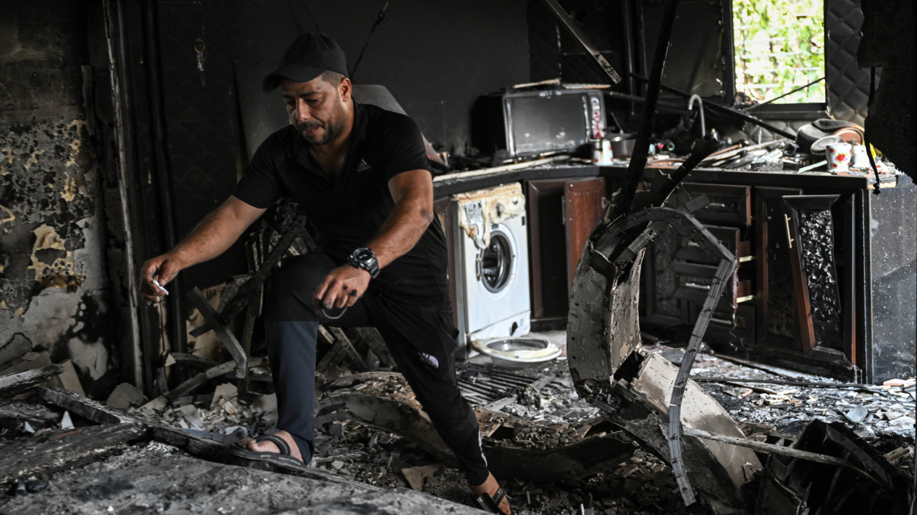 A man walks amid the charred remains of a kitchen in home in the Jenin refugee camp, 6 September 2024 (AFP)