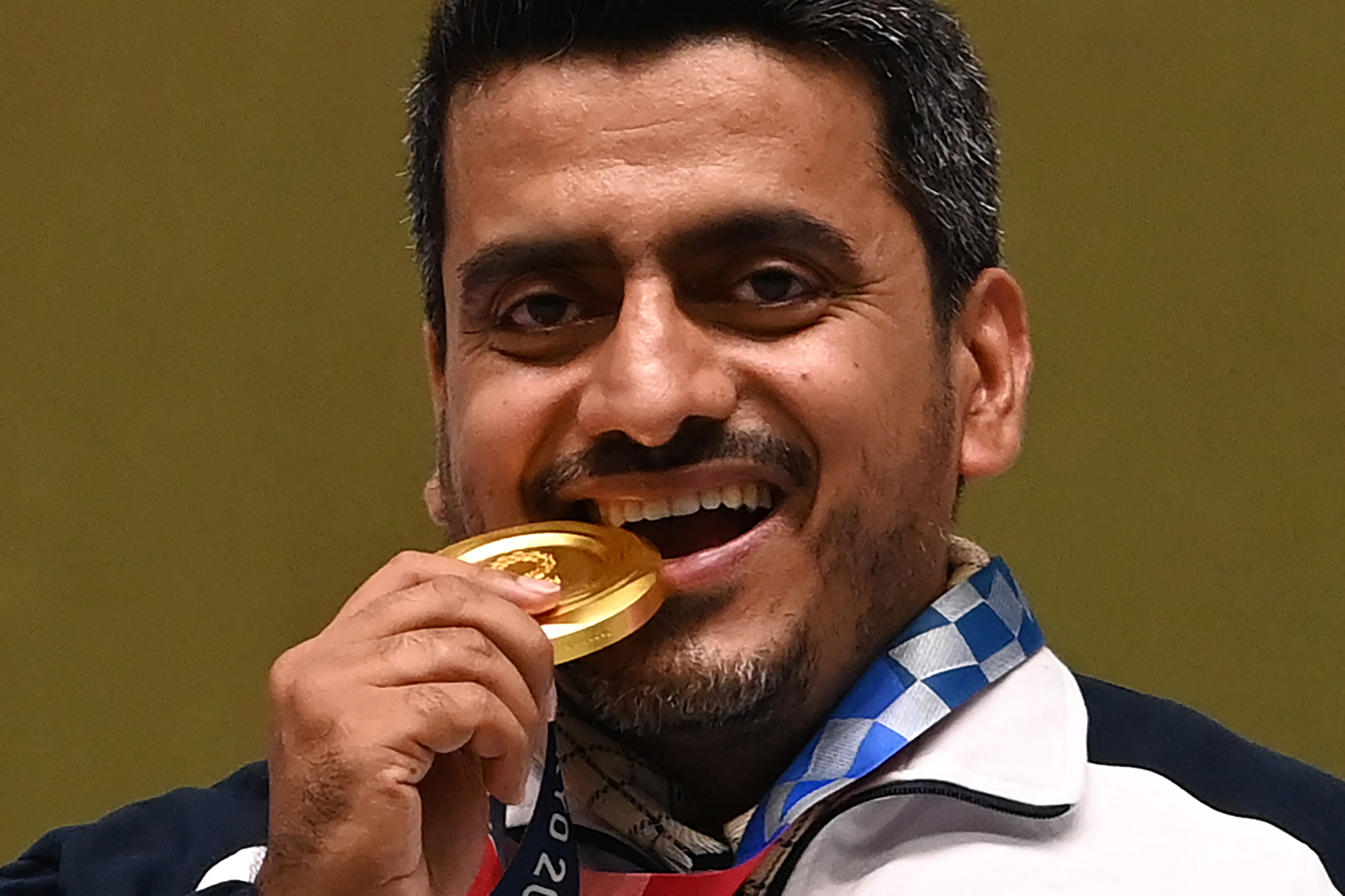 Le médaillé d’or iranien Javad Foroughi célèbre sa victoire en finale du pistolet à air comprimé 10&nbsp;mètres sur le podium (AFP)