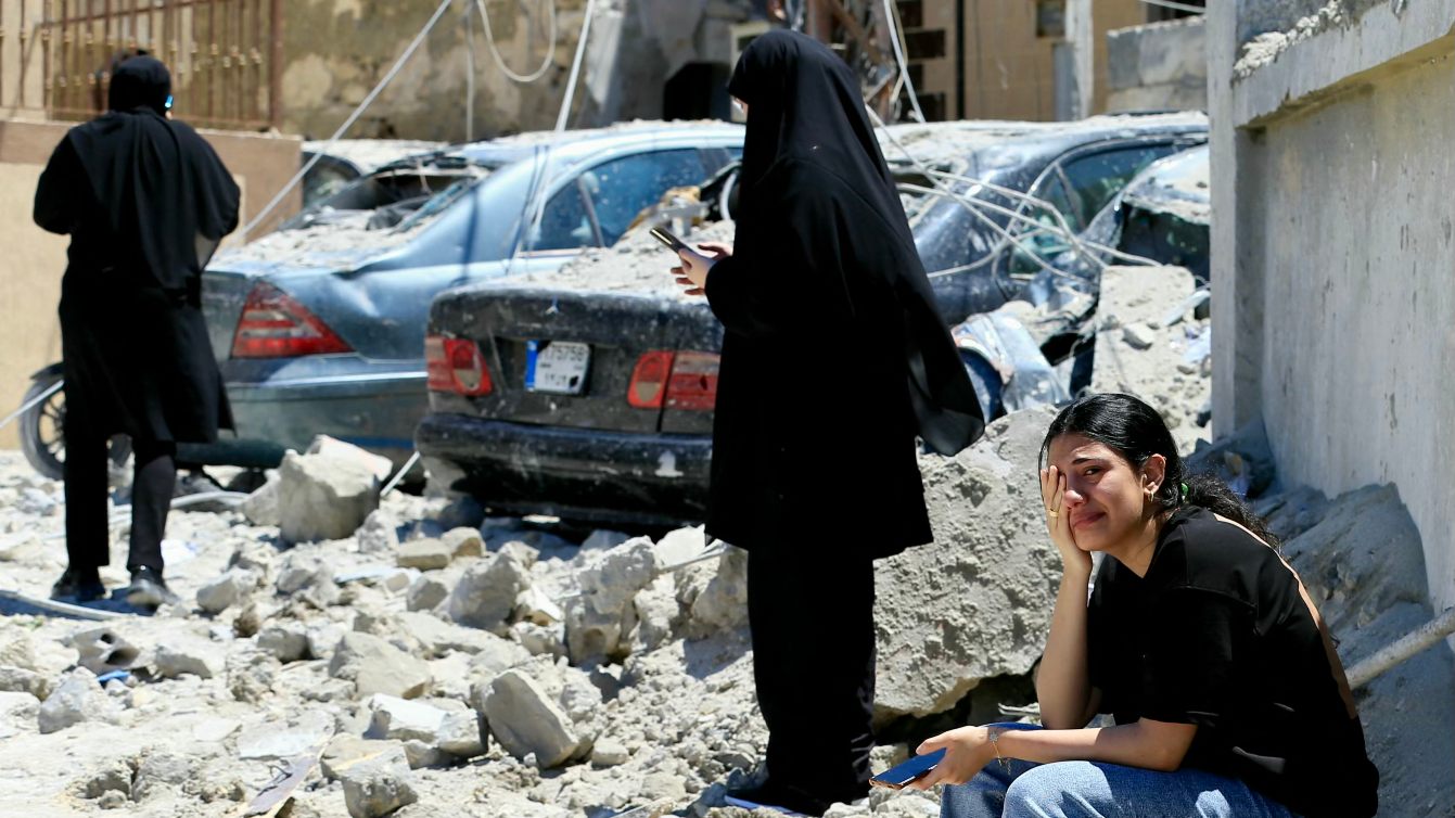 Lebanese woman weeps while sitting on rubble at the site of an Israeli airstrike in the southern village of Qennarit, 20 June 2026 (AFP)