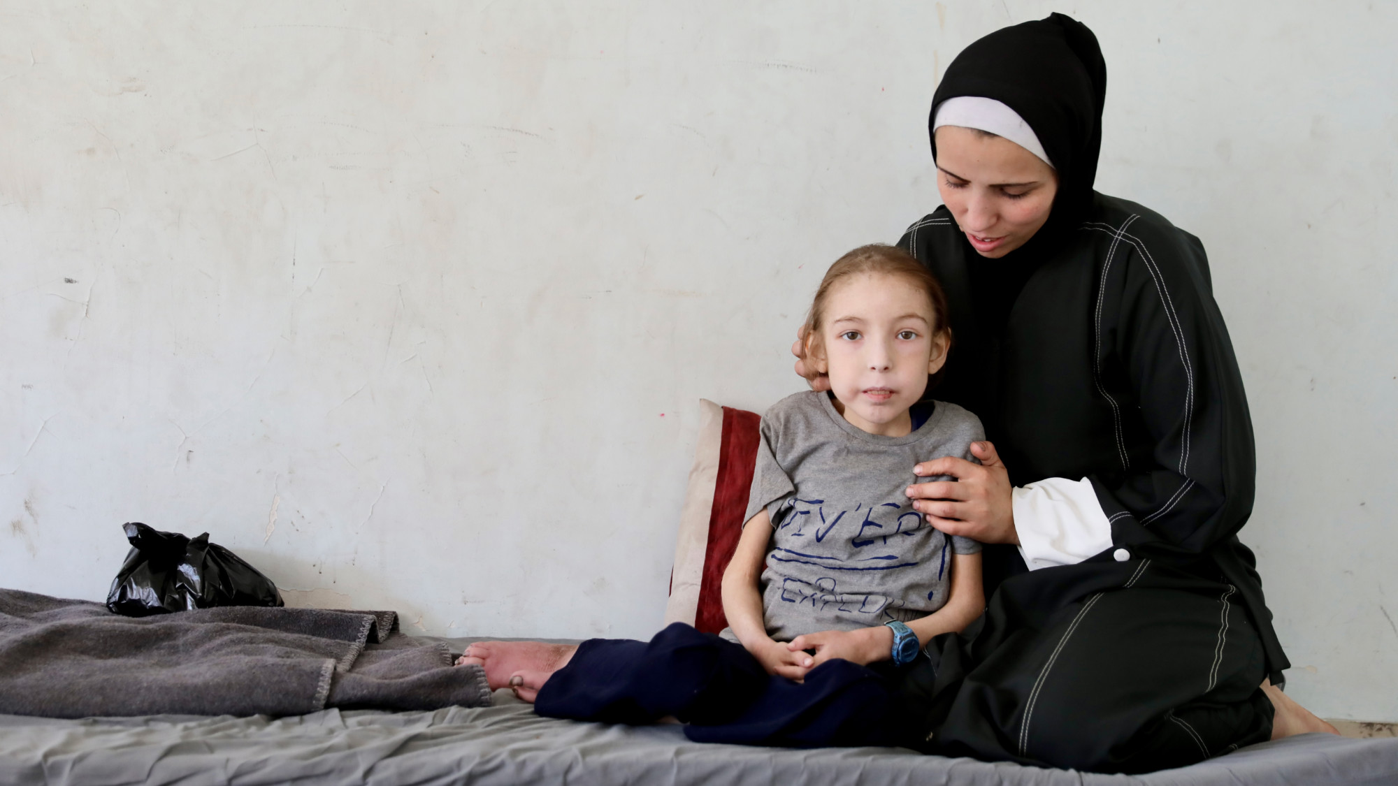 Rahaf Ayyad sits besides her mother, , in Gaza City (MEE/Mohammed al-Hajjar)