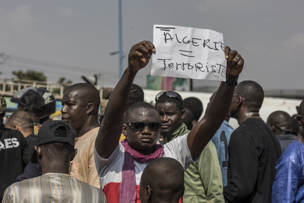 A demonstrator holds a placard with written 