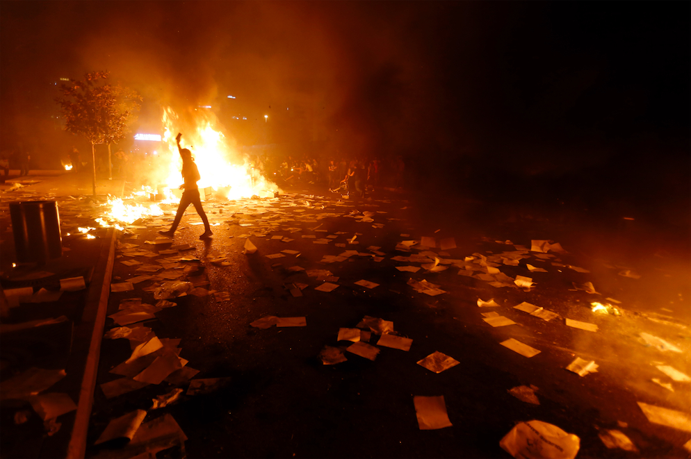 In a pitch-black Mar Mikhail neighbourhood, near the Électricité du Liban building, pedestrians are silhouetted by headlights and the green flood lamps of international rescue teams partially illuminate the ruins of Beirut Port’s grain silo. Shot 10 August.