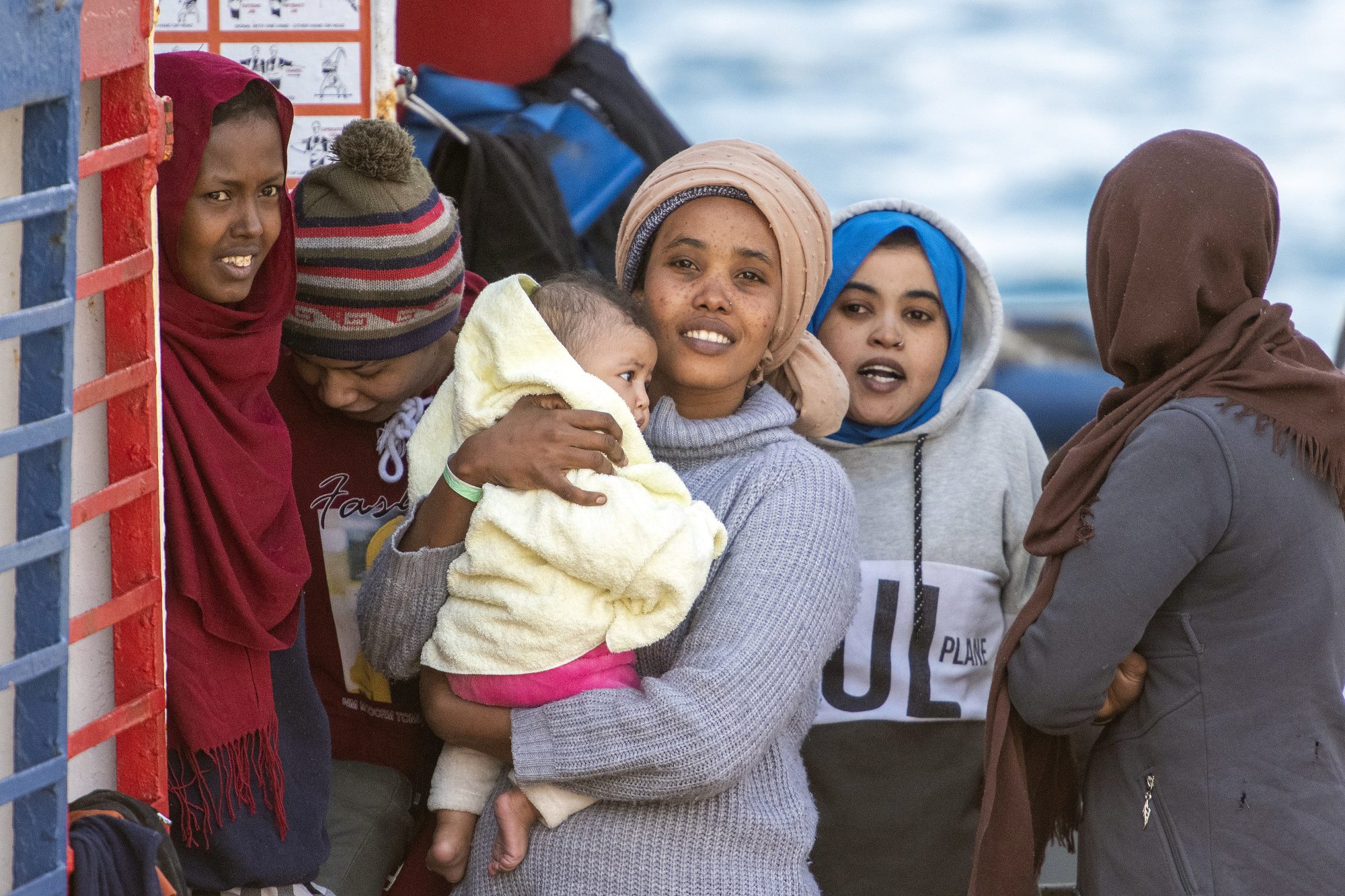 Migrants rescued in the Mediterranean sea wait before disembarking from the Sea Watch NGO's ship on 27 February 2020 in the port of Messina, Sicily (AFP)