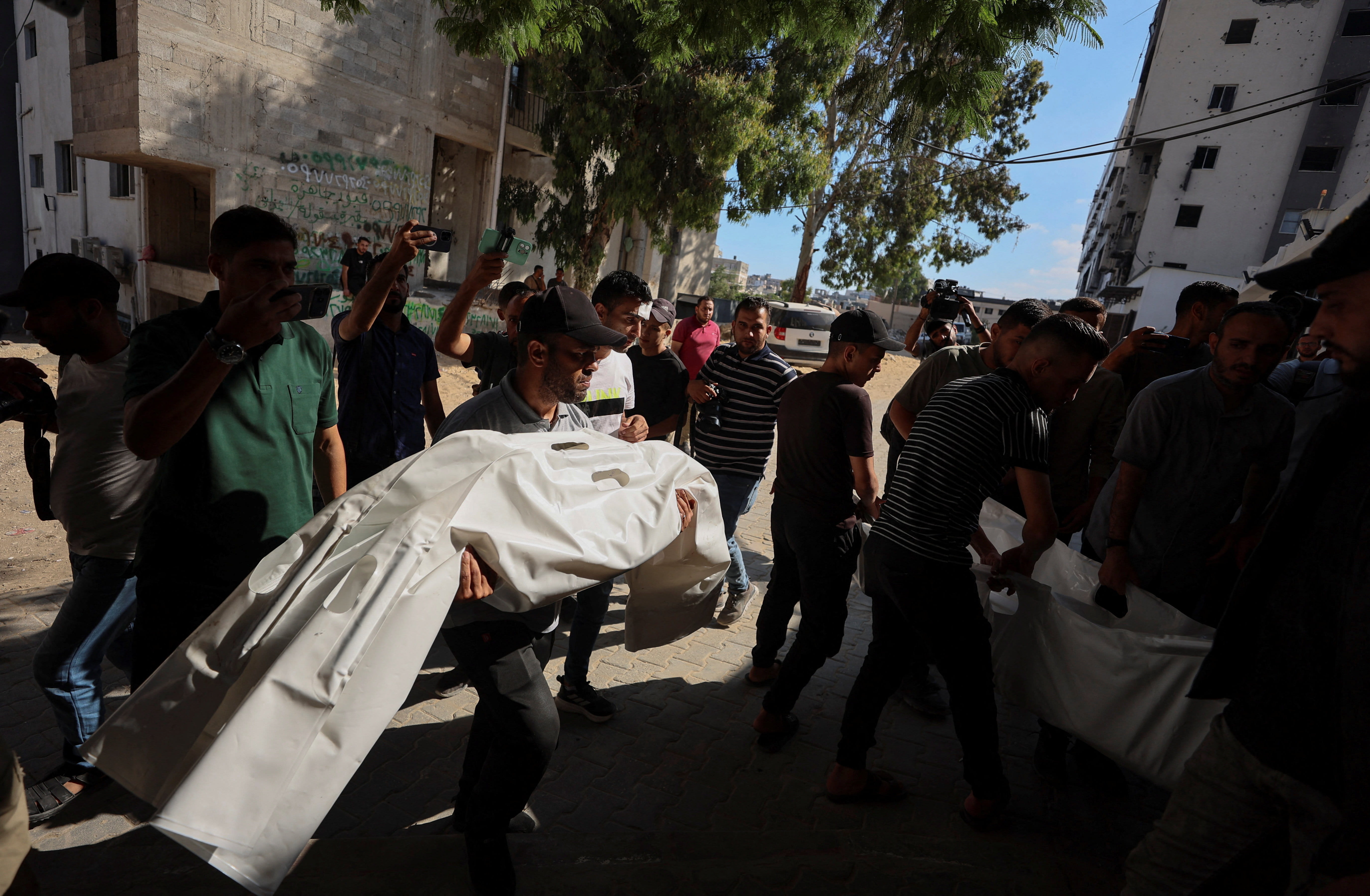 Mourners carry bodies during the funeral of Palestinians killed in an Israeli strike, according to medics, at Al-Shifa Hospital in Gaza City, June 20, 2026. REUTERS/Dawoud Abu Alkas