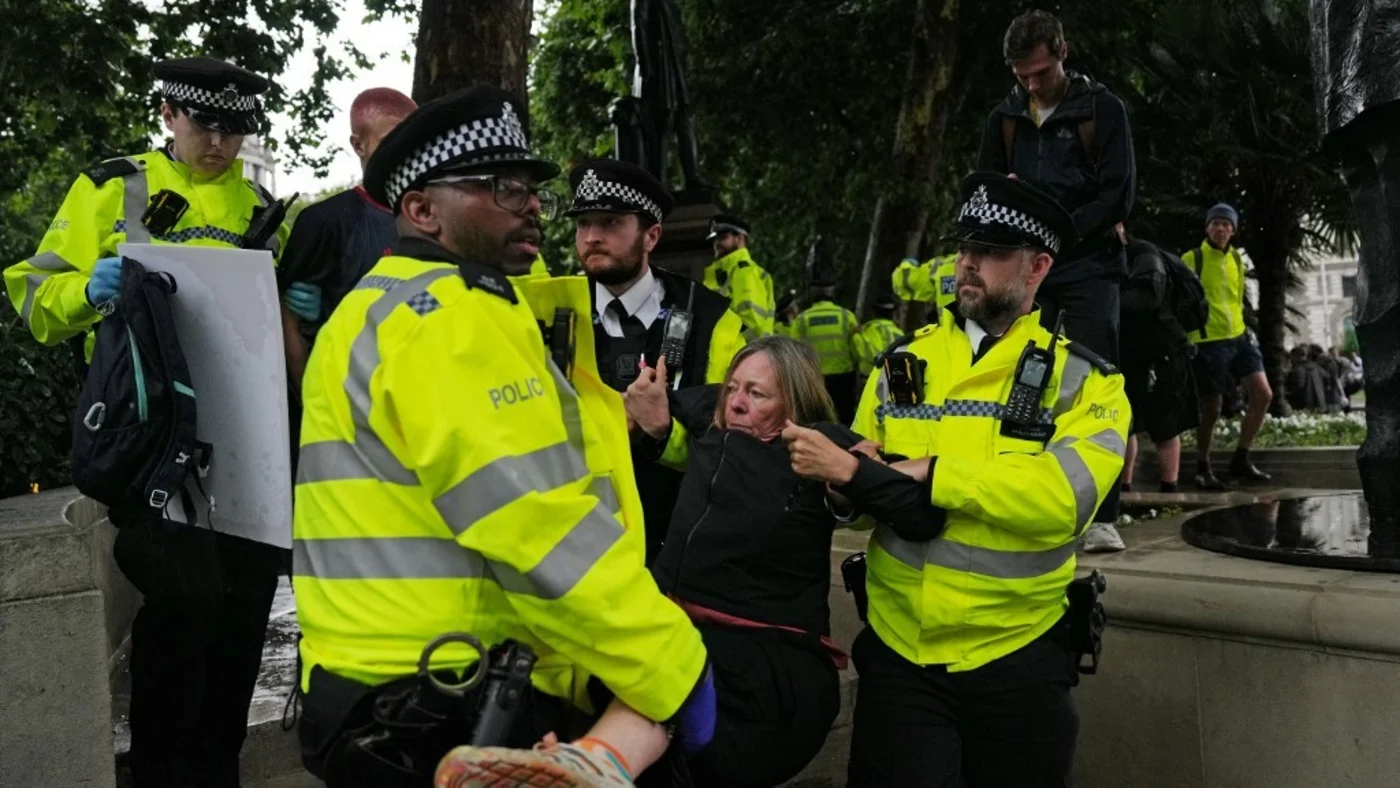 A protester is carried away by police officers during a demonstration in support of the proscribed group Palestine Action in Parliament Square, central London on 19 July 2025 (Carlos Jasso/AFP)
