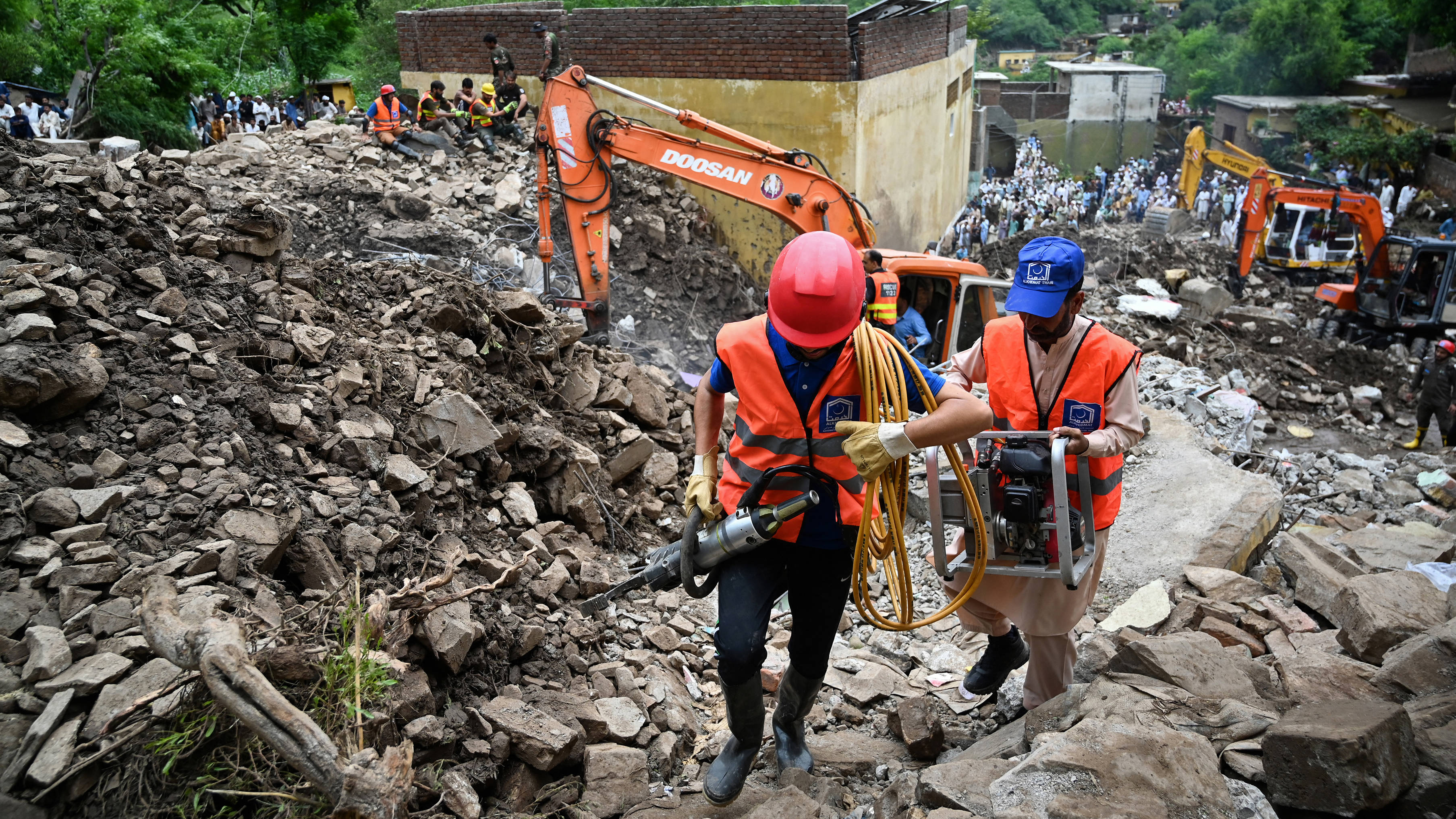 Rescue workers try to clear away the rubble of collapsed houses as they search for victims, a day after a flash flood in Dalori village( Aamir QURESHI /AFP)