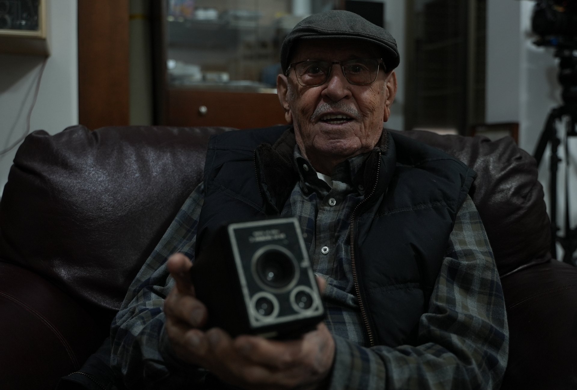 Maurice Michel tient un appareil photo utilisé par son père (MEE)