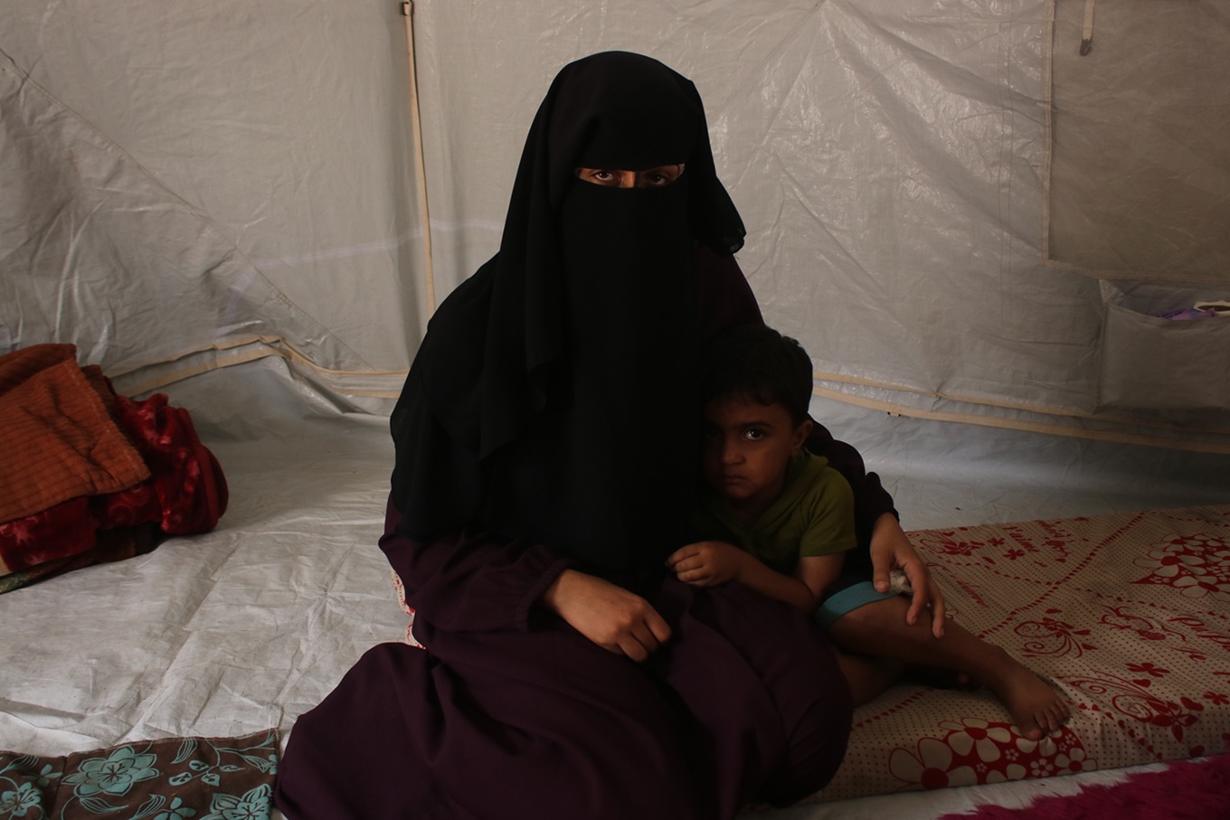Rawand Salim, a 27-year-old widowed mother of two, and her three-year-old son Subhi in their tent in Gaza City’s al-Zaytoun neighbourhood, in October 2025 (Abdallah al-Naami/MEE)