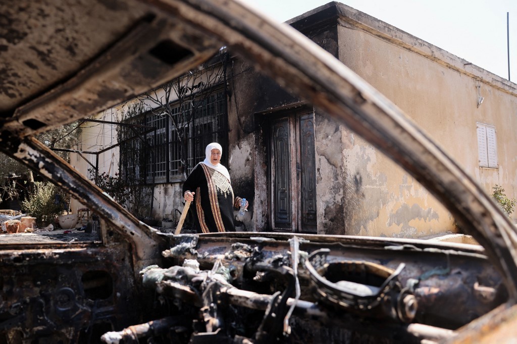 A Palestinian woman outside her house, which was set on fire by Israeli settlers the day before, in Turmus Ayya near the occupied West Bank city of Ramallah, on 22 June 2023 (Ahmad Gharabi/AFP)