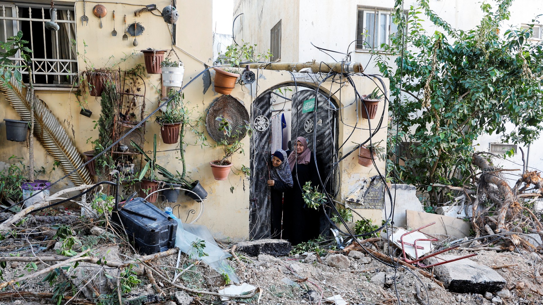 Palestinians look out from a doorway following a raid in Jenin in the Israeli-occupied West Bank, November 29, 2023
