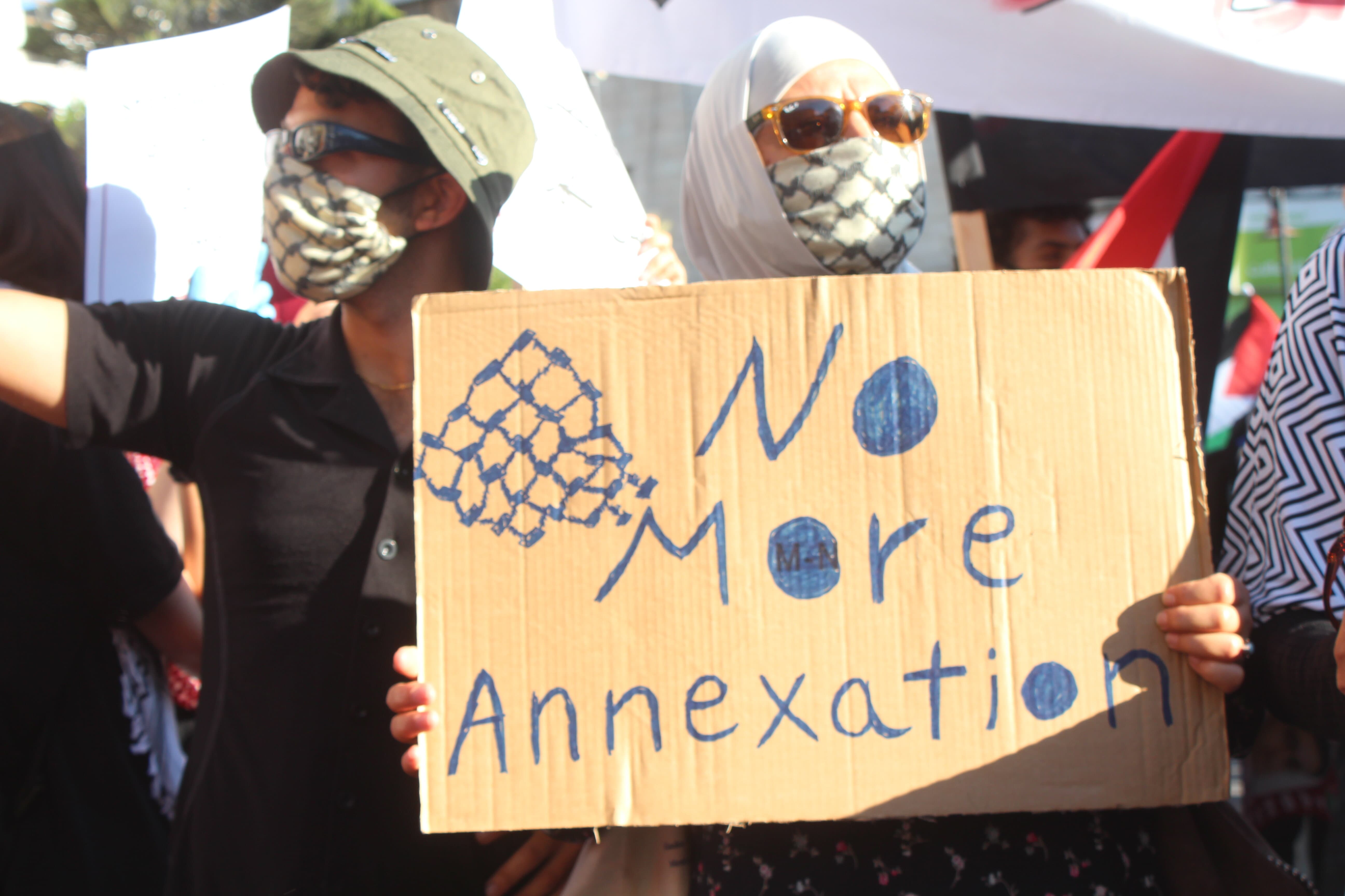 A demonstrator holds up a sign saying 'No more annexation' at a protest in Ramallah on 1 July