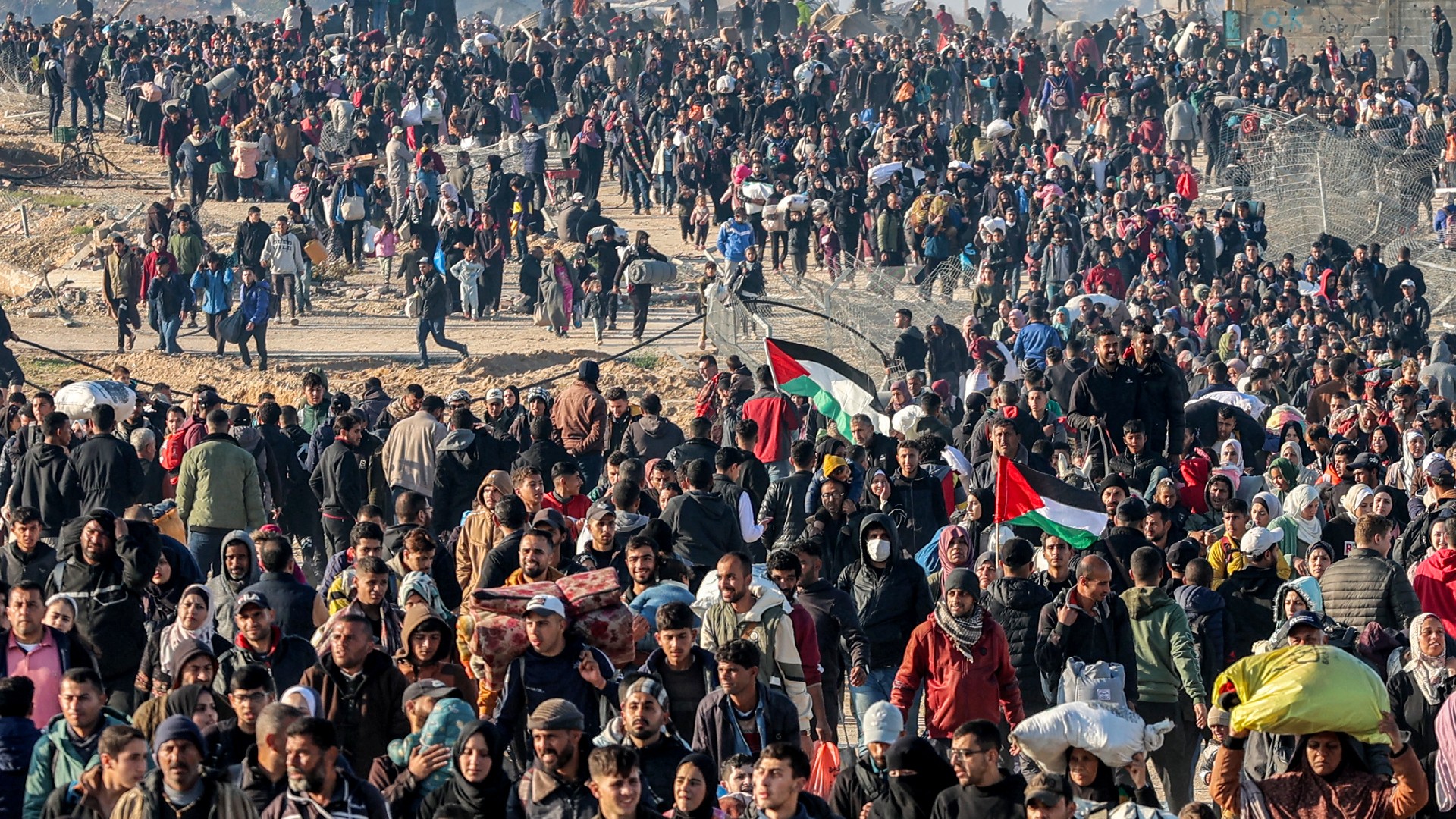 People walk along Gaza's coastal al-Rashid Street to cross the Netzarim corridor from the southern Gaza Strip into the north on January 27, 2025.