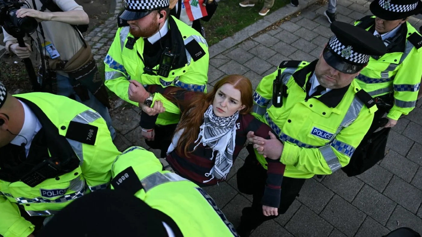 Police officers carry away a protestor outside of the Labour Party's conference in Liverpool, north-west England, on 28 September 2025 (MEE)