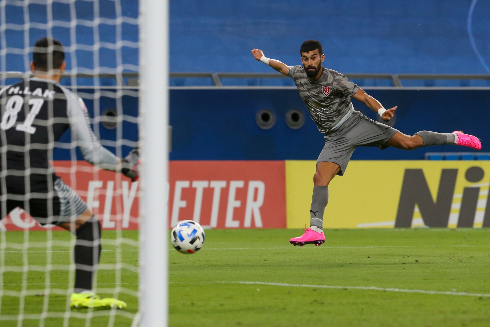 Duhail defender Ramin Rezaeian attempts a shot on Persepolis' goalkeeper Hamed Lak during a AFC Champions League match between Iran's Persepolis and Qatar's al-Duhail on 21 September 2020 (AFP)