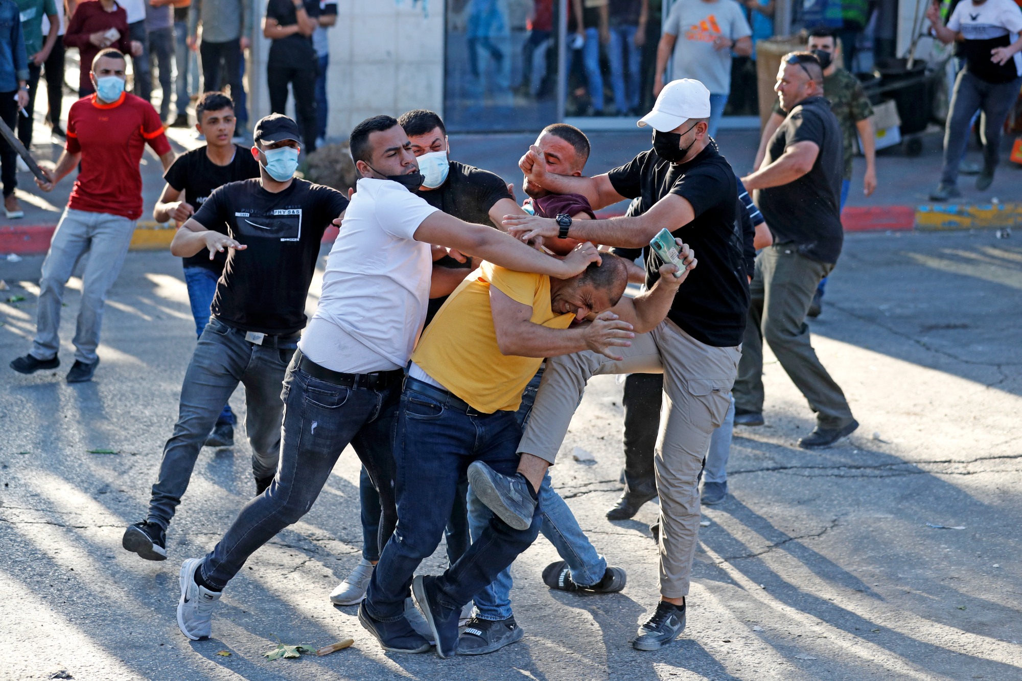 Palestinian plainclothes officers detain a man during a demonstration in the city of Ramallah in the occupied West Bank on 26 June 2021 (AFP)