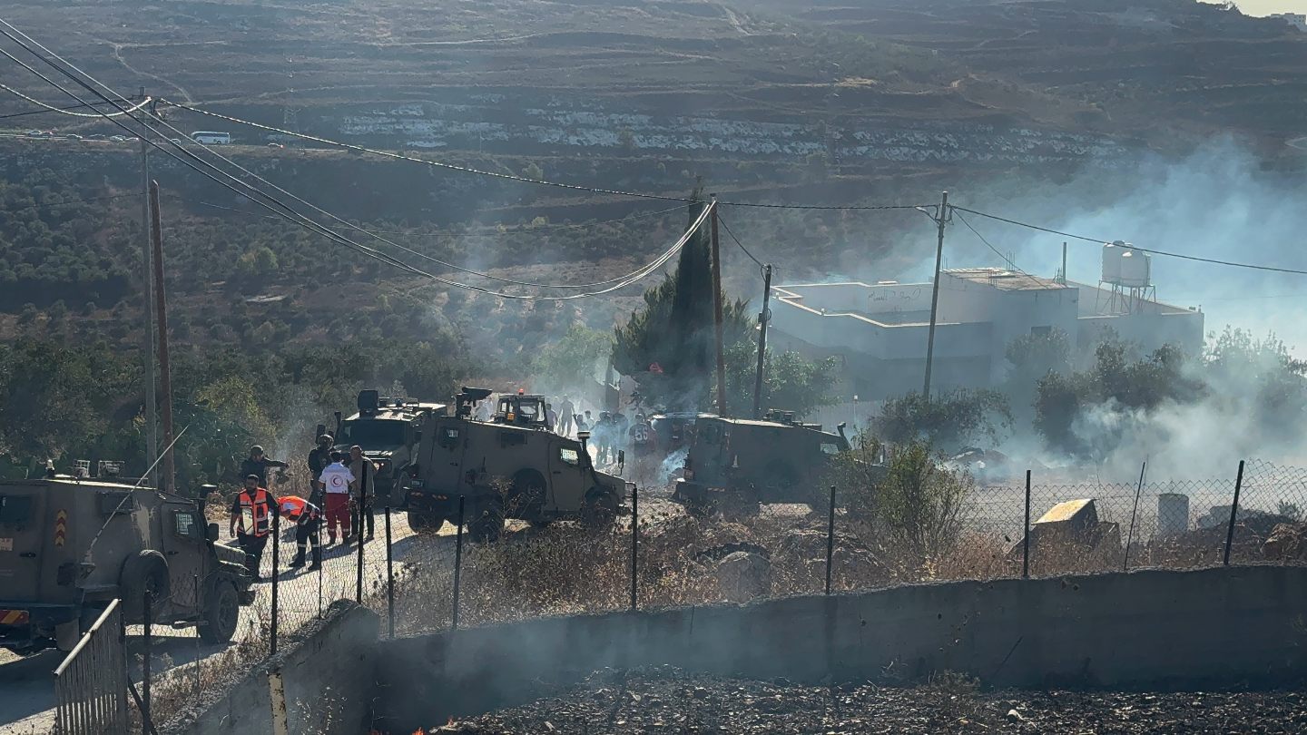 Residents douse flames engulfing a car outside a home attacked by Israeli settlers in the Palestinian village of Sarra, southwest of Nablus in the occupied West Bank (Atiq/Middle East Eye)