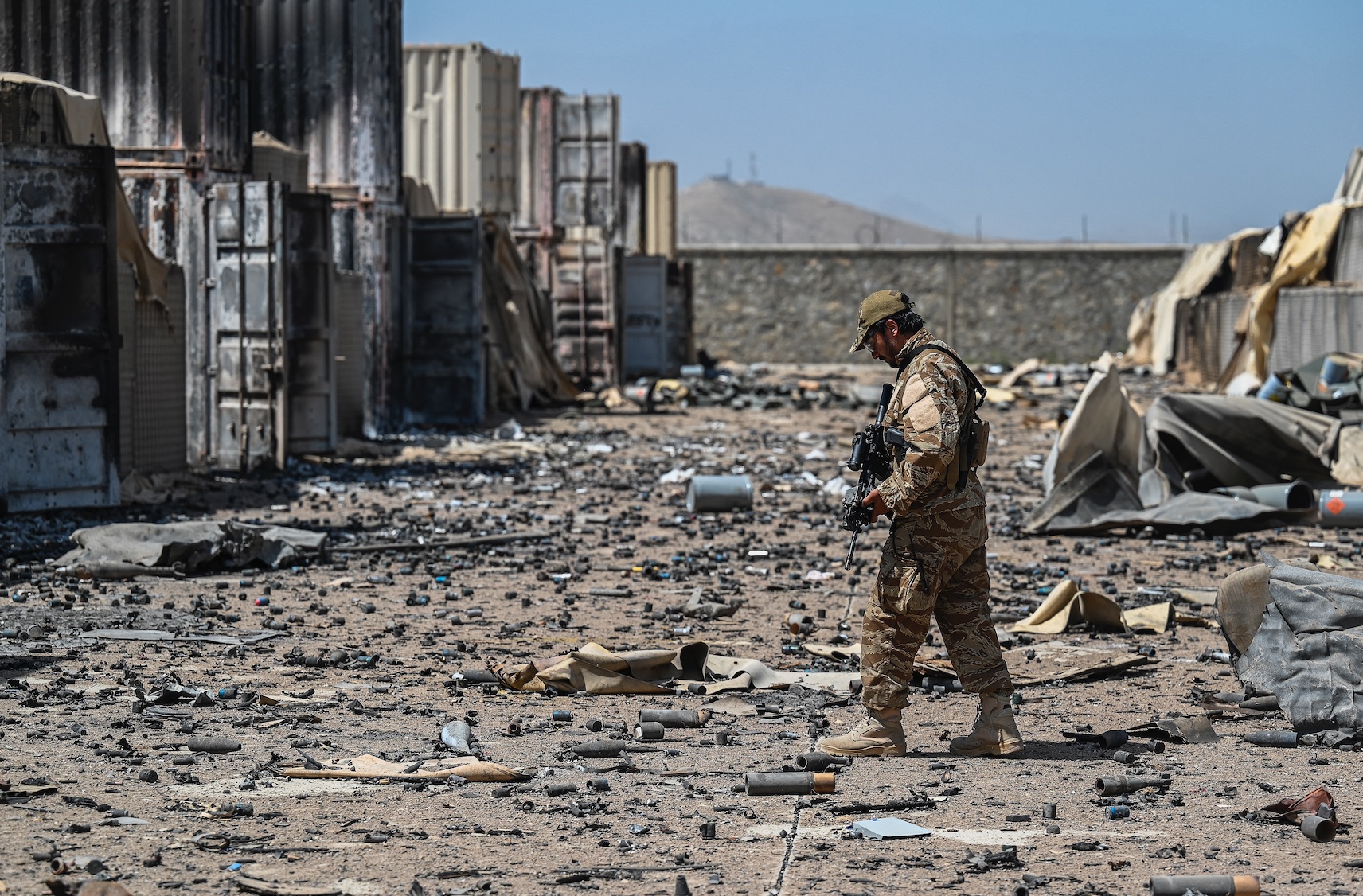 Un militaire taliban marche au milieu des débris de la base détruite de la Central Intelligence Agency (CIA) dans le district de Deh Sabz, au nord-est de Kaboul, le 6 septembre (AFP/Aamir Qureshi)