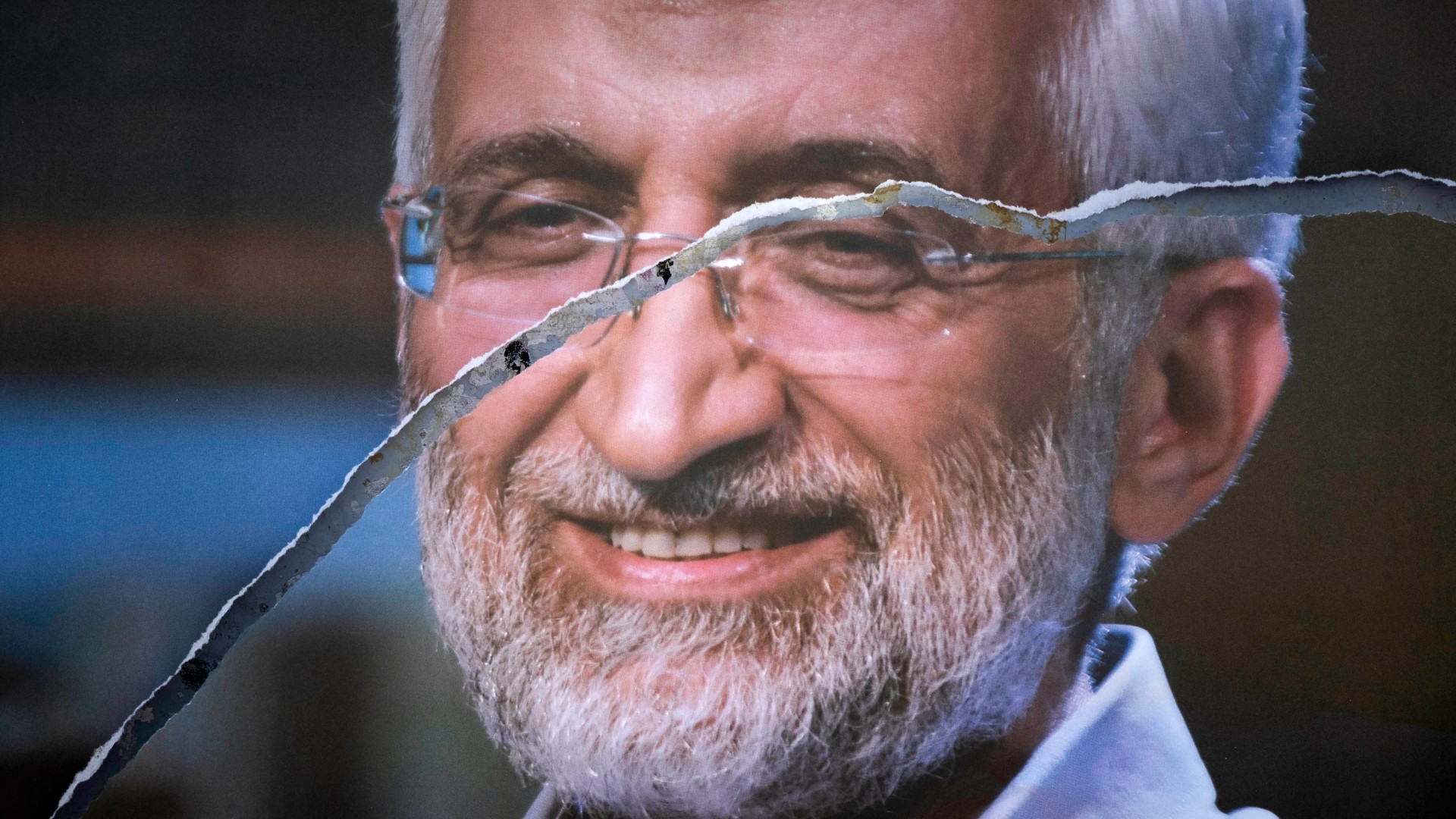 A torn electoral poster bearing the portrait of presidential candidate Saeed Jalili on a wall in downtown Tehran on 15 June, 2021 (AFP/Morteza Nikoubazl)